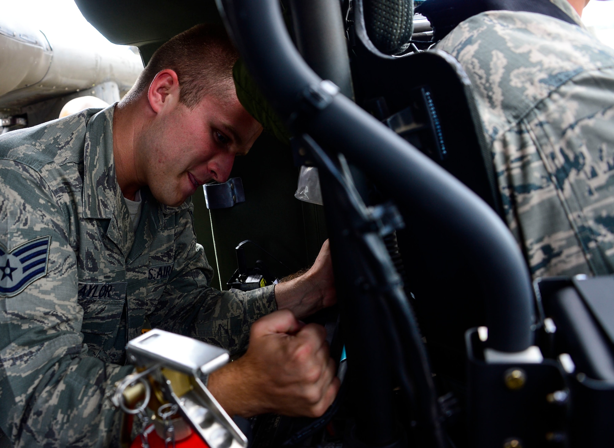 U.S. Air Force Staff Sgt. Samuel Taylor, 612th Air Base Squadron firefighter, tries to remove the pilot seat from UH-60 Blackhawk helicopter during aircraft crash rescue training with the 1-228th Aviation Regiment at Soto Cano Air Base, Honduras, Jan. 15, 2015.  At least once a quarter, the 612th ABS teams up with the 1-228th Avn. Reg. to review aircraft crash rescue training and emergency procedures for the UH-60 Blackhawk helicopter. (U.S. Air Force photo/Tech. Sgt. Heather Redman)