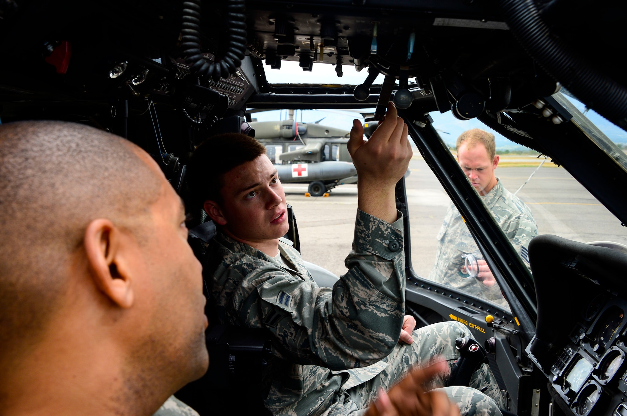 U.S. Air Force Airman 1st Class Andrew Divine, 612th Air Base Squadron firefighter, reviews the proper procedures of shutting down a UH-60 Blackhawk helicopter with U.S. Army Chief Warrant Officer 4 Ronald Rodgers, 1-228th Aviation Regiment battalion safety officer, at Soto Cano Air Base, Honduras, Jan. 15, 2015.  At least once a quarter, the 612th ABS teams up with the 1-228th Avn. Reg. to review aircraft crash rescue training and emergency procedures for the UH-60 Blackhawk helicopter. (U.S. Air Force photo/Tech. Sgt. Heather Redman)
