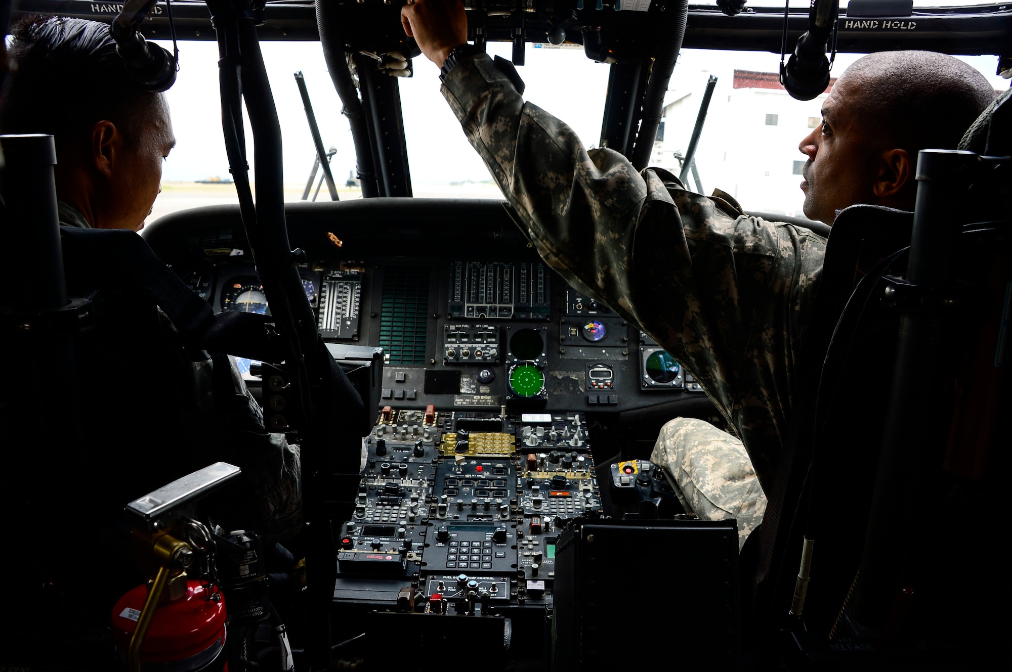 U.S. Army Chief Warrant Officer 4 Ronald Rodgers, 1-228th Aviation Regiment battalion safety officer, demonstrates the proper procedures of shutting down a UH-60 Blackhawk helicopter to U.S. Air Force Staff Sgt. Steven Saulo, 612th Air Base Squadron firefighter, at Soto Cano Air Base, Honduras, Jan. 15, 2015.  At least once a quarter, the 612th ABS teams up with the 1-228th Avn. Reg. to review aircraft crash rescue training and emergency procedures for the UH-60 Blackhawk helicopter. (U.S. Air Force photo/Tech. Sgt. Heather Redman)