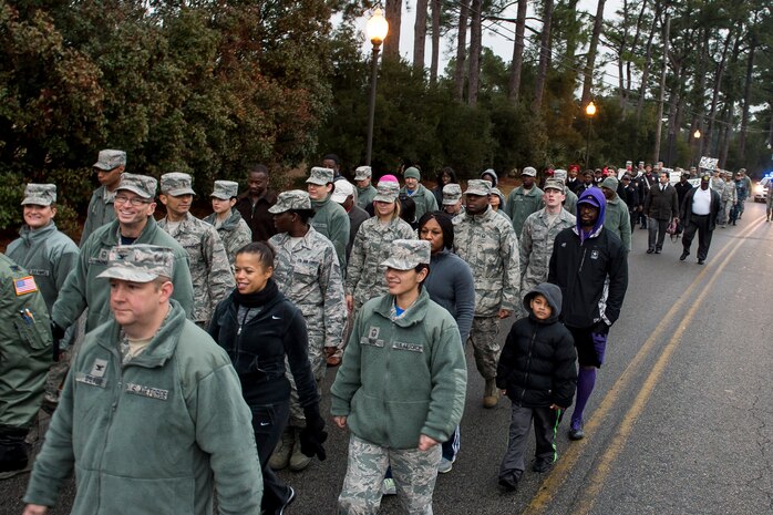 More than 100 service members, civilians and family members walk on Arthur Drive during a memorial march commemorating Martin Luther King Jr., Jan. 16, 2015, at Joint Base Charleston, S.C Following the march a celebratory program was held inside the chapel, with guest speaker Doug Hunter, the executive director of the Whitfield Center for Christian Leadership at Charleston Southern University. Martin Luther King Jr. Day is a federal holiday that celebrates his life and achievements as an influential leader of the American Civil Rights Movement.   (U.S. Air Force photo/Senior Airman Jared Trimarchi)  