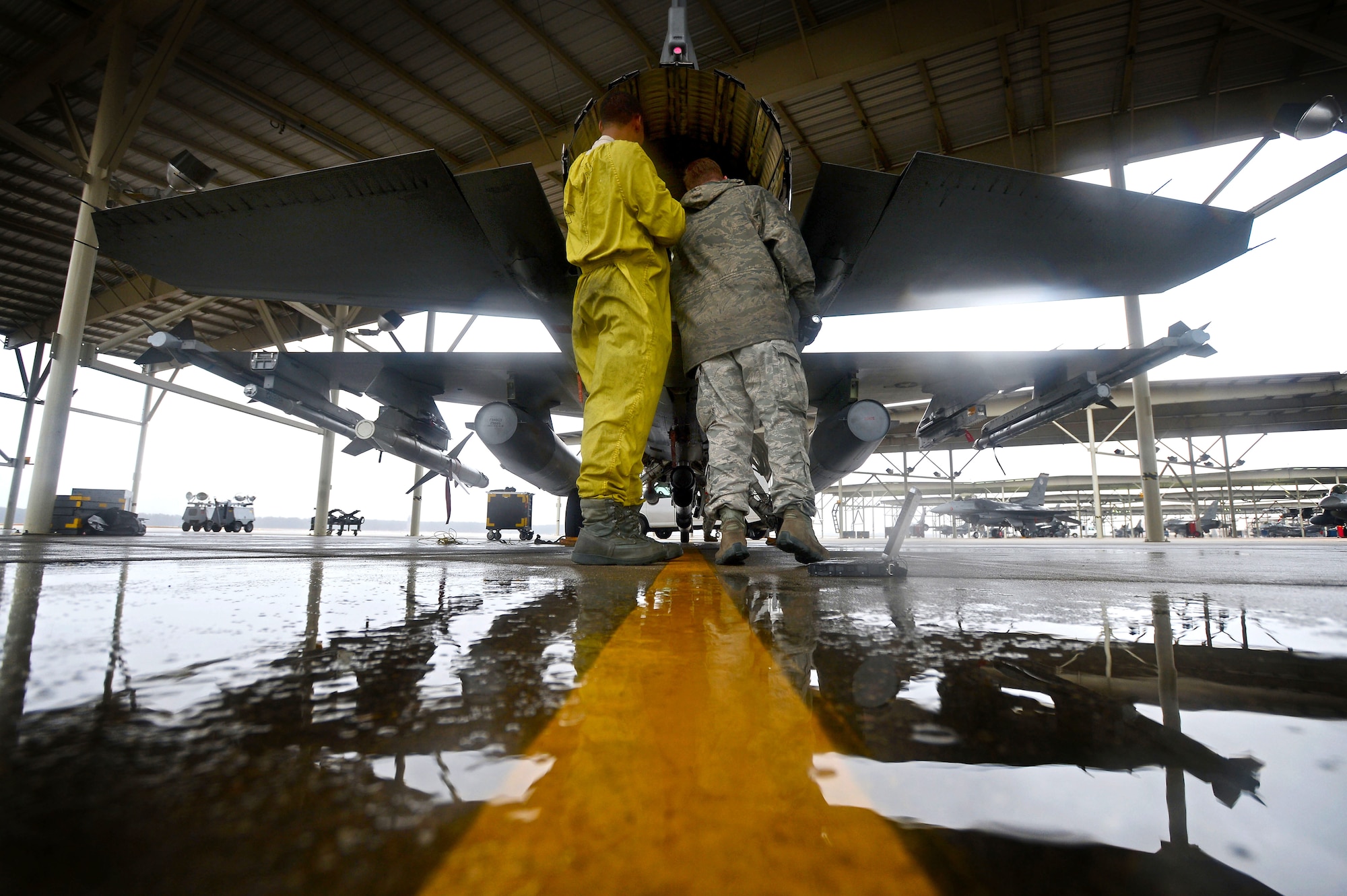 (From left) U.S. Air Force Staff Sgts. Edwin Watkins and Brandon Frazier, 20th Aircraft Maintenance Squadron tactical aircraft maintainers, inspect the exhaust of an F-16CM Fighting Falcon at Shaw Air Force Base, S.C., Jan. 13, 2015. To maintain readiness, 20th AMXS Airmen worked increased day and night operations during a five-day surge of flight sorties. (U.S. Air Force Senior Airman Jensen Stidham/Released)