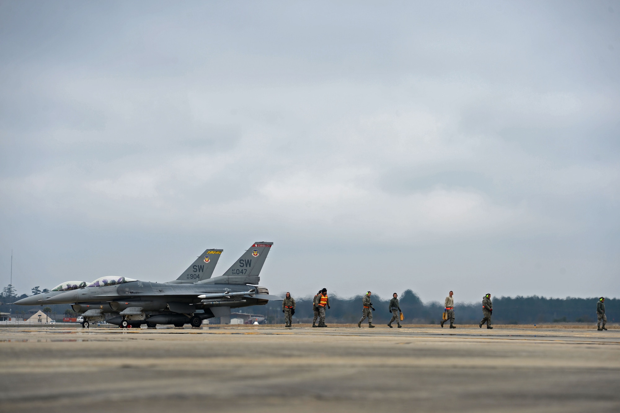 U.S. Air Force Airmen assigned to the 20th Maintenance Group, walk away from F-16CM Fighting Falcons after performing last-minute weapons checks at Shaw Air Force Base, S.C., Jan. 14, 2015. Before flight, tactical aircraft maintainers and load crew members ensured all missiles were attached correctly to ensure the safety of the pilot and aircraft. (U.S. Air Force photo by Senior Airman Jensen Stidham/Released) 