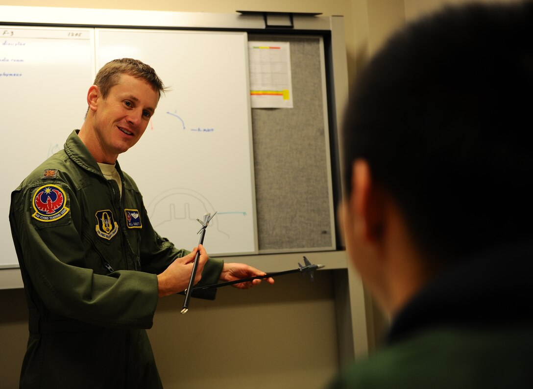 Maj. William Parrott, 43rd Flying Training Squadron Assistant Flight Commander, explains air to air maneuvers with a student pilot Jan. 13 at the 49th Fighting Training squadron on Columbus Air Force Base, Mississippi. Parrott, a reservist, contributed to a flight with Secretary of the Air Force Deborah Lee James like he and his entire reserve unit contributes to the Air Force mission every day. (U.S. Air Force photo/ Airman Daniel Lile)