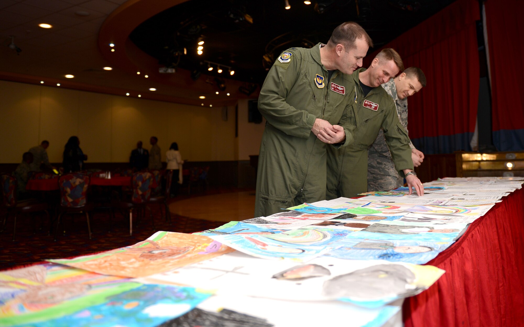 From left, U.S. Air Force Col. Kenneth T. Bibb Jr., 100th Air Refueling Wing commander, Col. David Cox, 100th ARW vice commander, and Chief Master Sgt. Tracy Jones, 100th ARW command chief, admire children’s drawings during a Dr. Martin Luther King Jr. birthday observance luncheon Jan. 16, 2015, at the Galaxy Club on RAF Mildenhall, England. The drawings, by elementary students from RAF Feltwell, depicted images of King and contained a short passage on what he meant to them. (U.S. Air Force photo by Senior Airman Kate Maurer/Released)