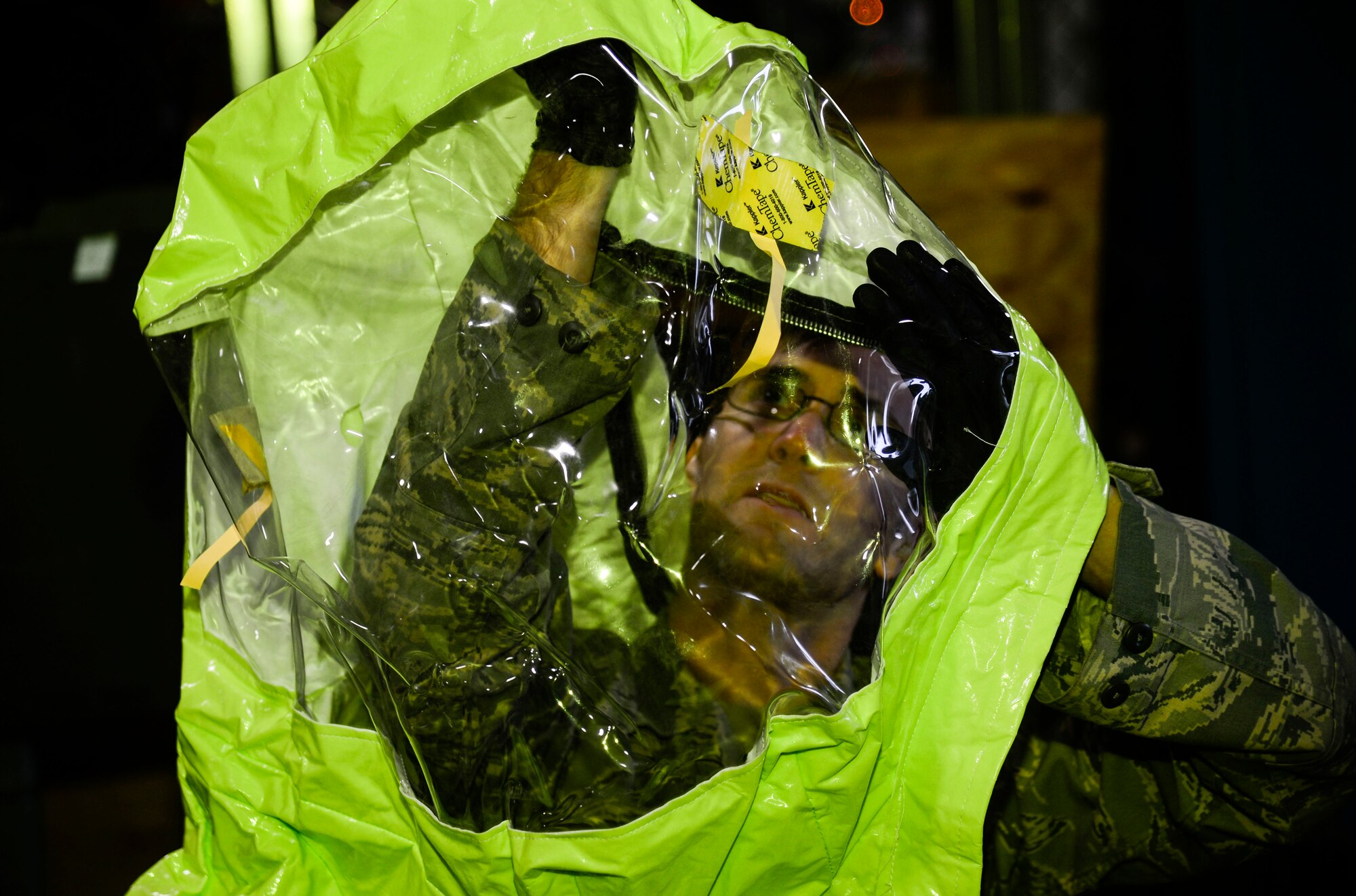 U.S. Air Force Senior Airman Zach Day, 633rd Civil Engineer Squadron emergency management technician, prepares a hazardous material suit for use at Langley Air Force Base, Va., Jan. 14, 2015. Airmen from bioenvironmental engineering, civil engineer emergency management and fire emergency services took part in a three-day Integrated Base Emergency Response and Capability training to enhance their response to a potential chemical, biological, radiological, nuclear or high-yield explosives threat. (U.S. Air Force photo by Senior Airman Kayla Newman/Released) 