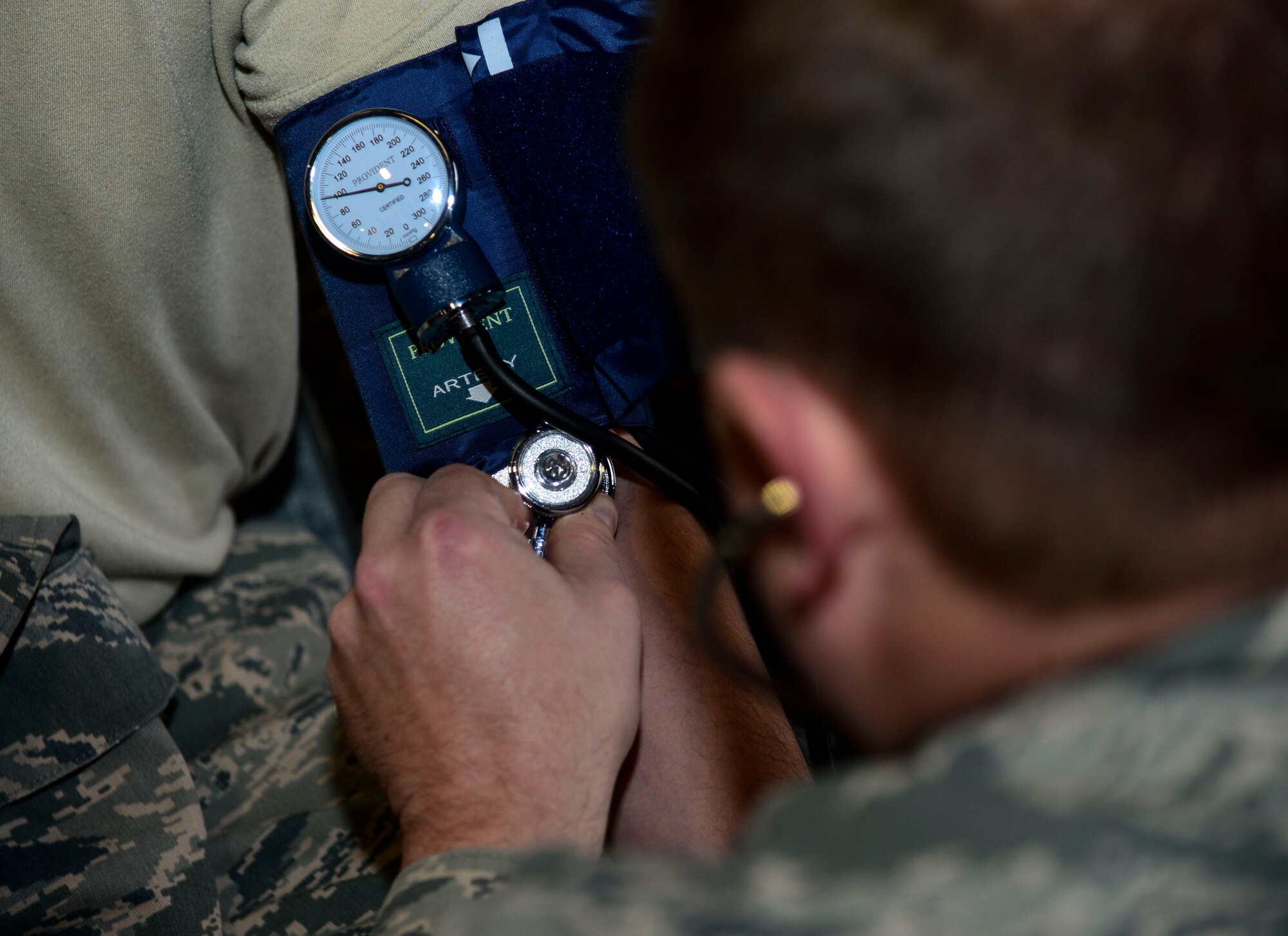 U.S. Air Force Master Sgt. Robert Stewart, 192nd Mission Support Group emergency management technician, checks the vital signs of an Airman during Integrated Base Emergency Response and Capability training at Langley Air Force Base, Va., Jan. 14, 2015. Before putting on hazardous material suits, Airmen had their blood pressure and heart rate monitored. (U.S. Air Force photo by Senior Airman Kayla Newman/Released)