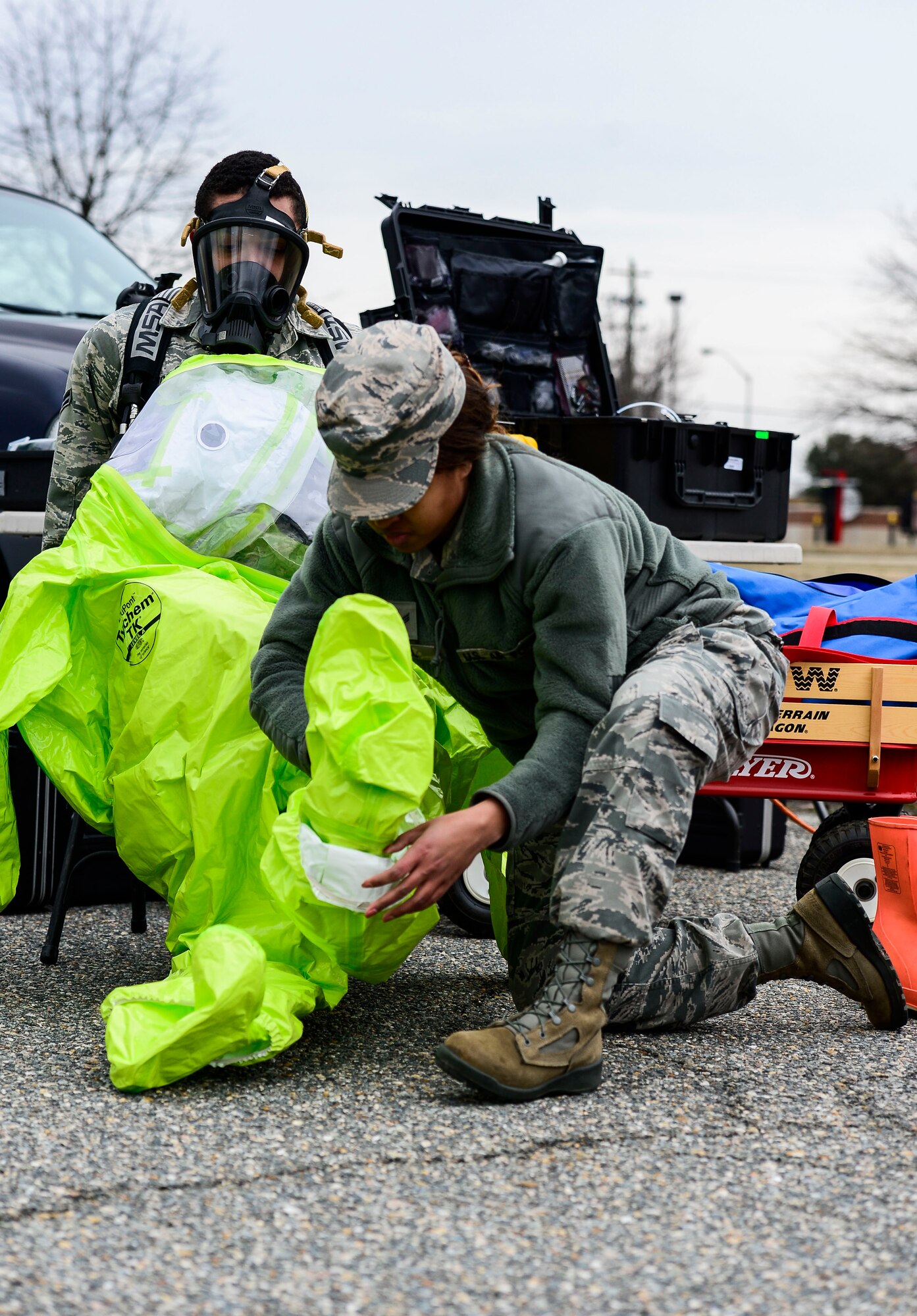U.S. Air Force Senior Airman Felicia Still, 633rd Aerospace Medicine Squadron bioenvironmental engineer technician, assists Airman 1st Class Alex McClendon, 633rd AMDS bioenvironmental engineer technician, with donning a hazardous material suit during Integrated Base Emergency Response and Capability training at Langley Air Force Base, Va., Jan. 13, 2015. A team of Airmen entered a simulated contaminated area to test for hazardous materials. (U.S. Air Force photo by Senior Airman Kayla Newman/Released)