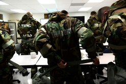 Airmen don their ground crew ensemble in the chemical, biological, radiological, and nuclear survival skills class at the readiness and emergency management flight on Laughlin Air Force Base, Texas, Jan. 14, 2015. All participants were expected to perform mission-oriented readiness and protective posture level procedures to ensure they are able to operate in a CBRN contaminated environment. (U.S. Air Force photo by Airman 1st Class Ariel D. Delgado)