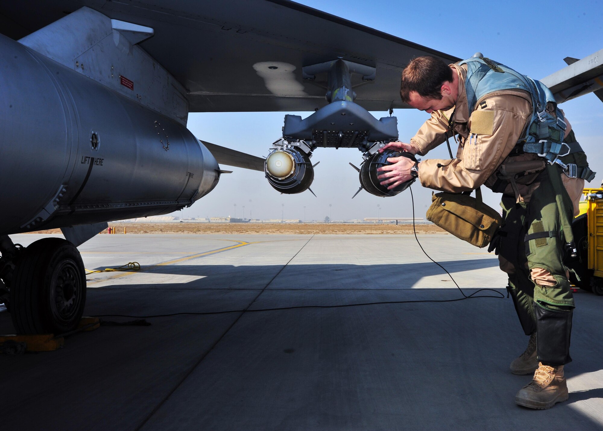 A U.S. Air Force F-16 pilot assigned to the 4th Expeditionary Fighter Squadron, inspects an F-16 Fighting Falcon prior to a mission Jan. 9, 2015 at Bagram Airfield, Afghanistan. The F-16 is a multi-role fighter aircraft that provides air superiority enabling freedom of movement for troops on the ground as well as close air support for troops engaged in combat. It provides a relatively low-cost, high-performance weapon system for the United States and allied nations. (U.S. Air Force photo by Staff Sgt. Whitney Amstutz/released)