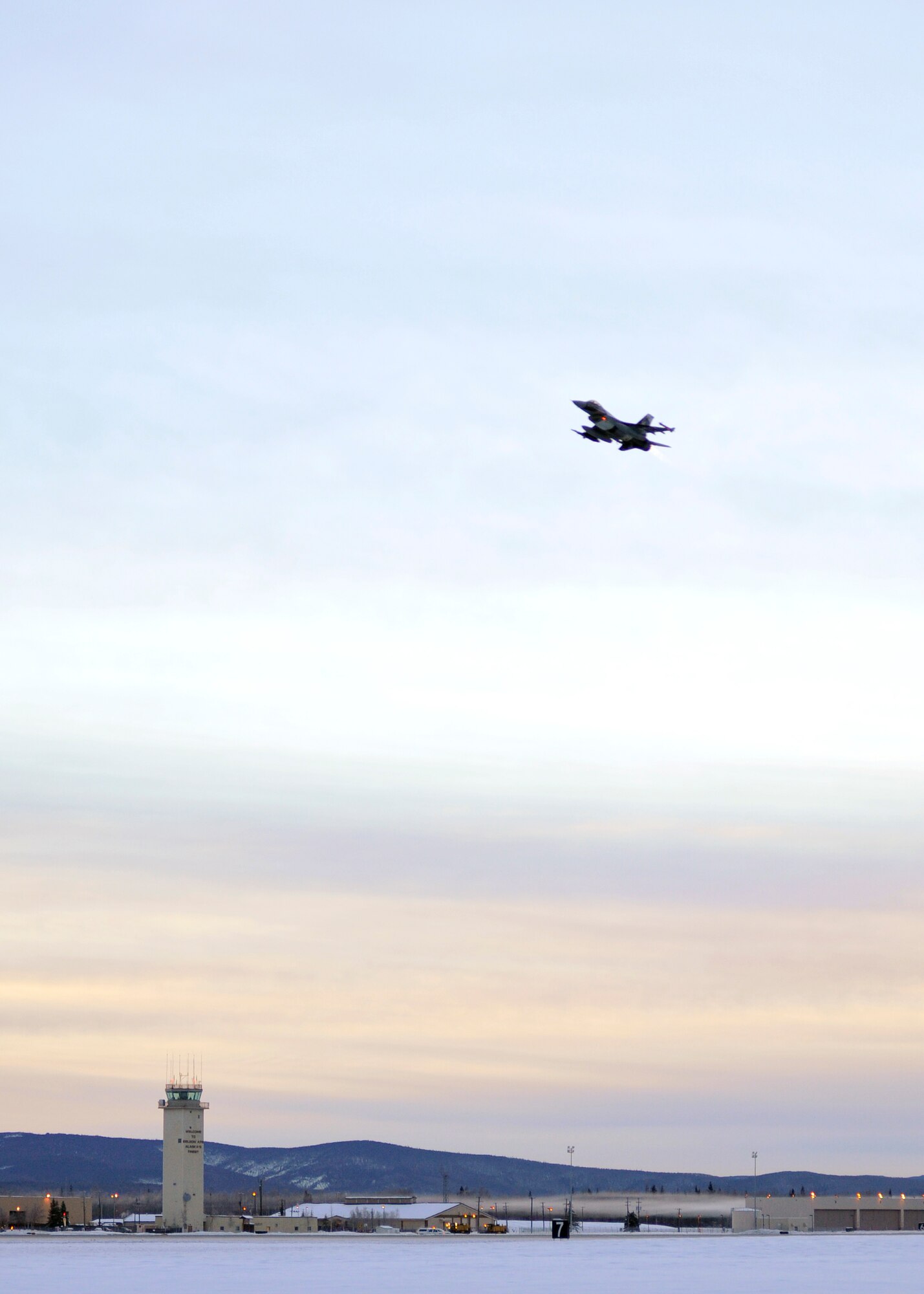 One of 14 U.S. Air Force F-16 Fighting Falcon aircraft with the 18th Aggressor Squadron takes off from Eielson Air Force Base, Alaska, shortly after sunrise Jan. 17, 2015, in transit to Hickam Air Force Base, Hawaii, and Andersen Air Force Base, Guam to participate in the SENTRY ALOHA and COPE NORTH exercises. More than 150 maintainers will keep the Aggressors in the air during the exercises, which are meant to prepare U.S. Airmen, Sailors and Marines along with coalition partners in the Pacific theater of operations for contingency operations if the need arises. (U.S. Air Force photo by Master Sgt. Karen J. Tomasik)