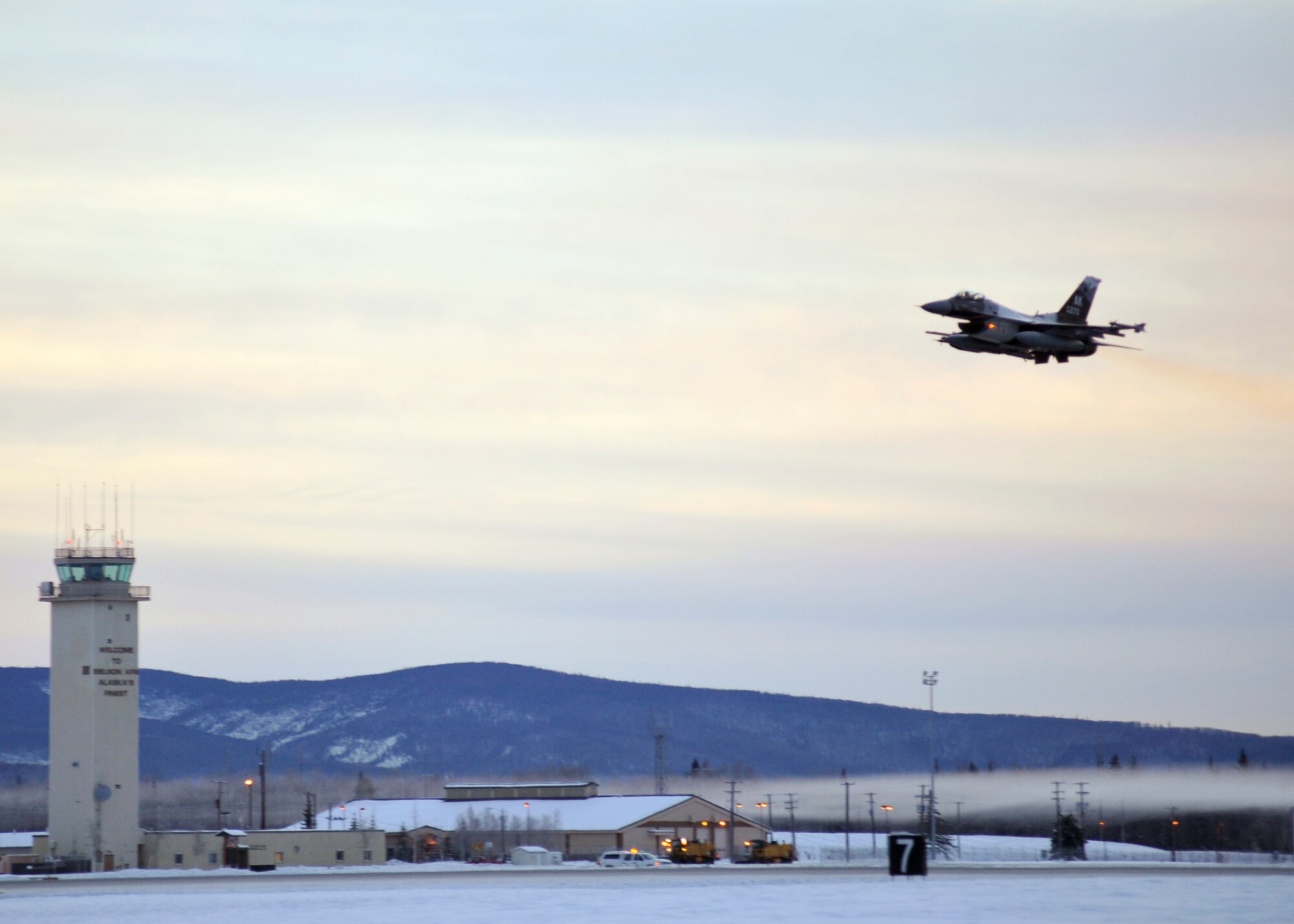 One of 14 U.S. Air Force F-16 Fighting Falcon aircraft with the 18th Aggressor Squadron takes off from Eielson Air Force Base, Alaska, shortly after sunrise Jan. 17, 2015, in transit to Hickam Air Force Base, Hawaii, and Andersen Air Force Base, Guam to participate in the SENTRY ALOHA and COPE NORTH exercises. More than 150 maintainers will keep the Aggressors in the air during the exercises, which are meant to prepare U.S. Airmen, Sailors and Marines along with coalition partners in the Pacific theater of operations for contingency operations if the need arises. (U.S. Air Force photo by Master Sgt. Karen J. Tomasik)