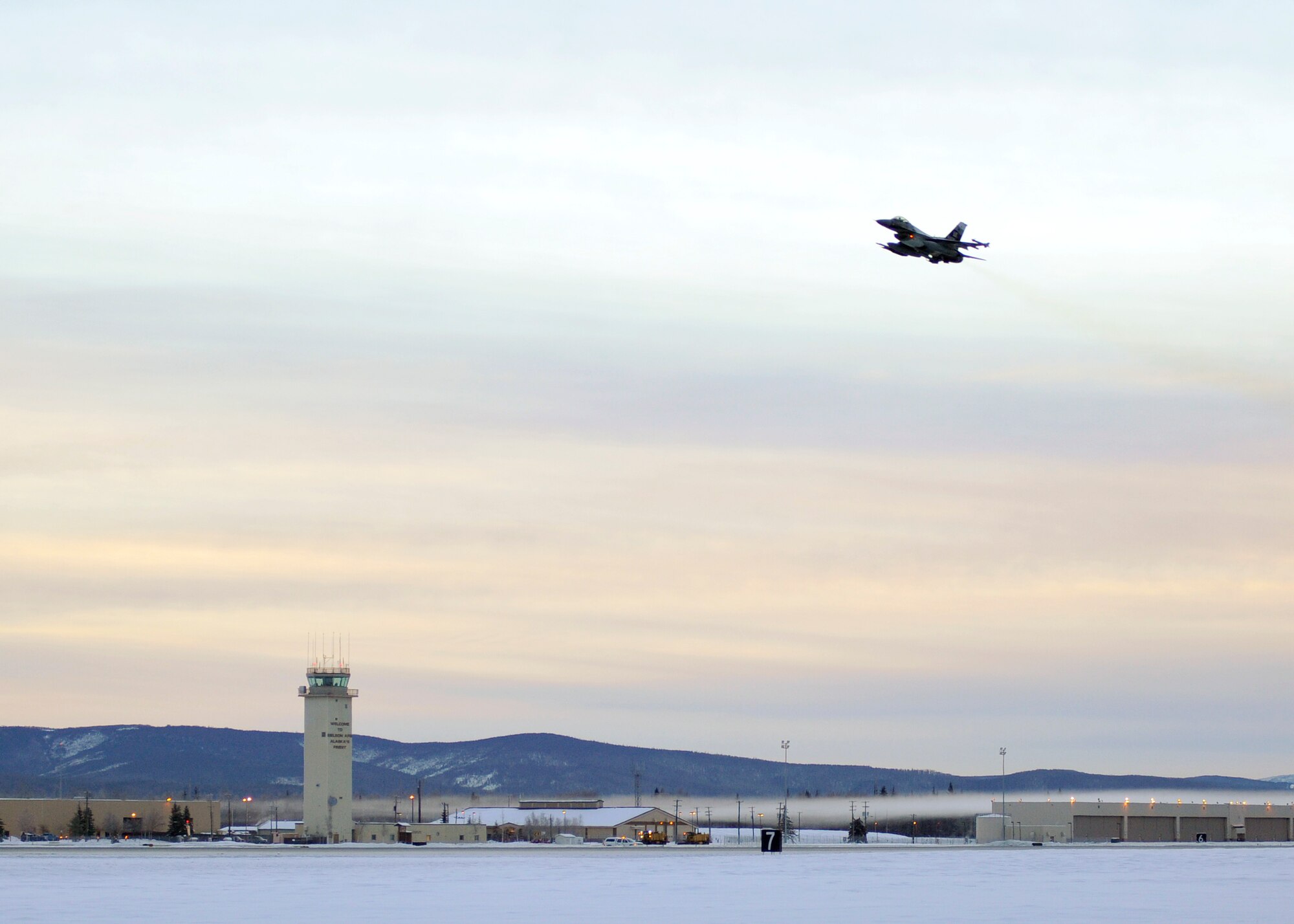 One of 14 U.S. Air Force F-16 Fighting Falcon aircraft with the 18th Aggressor Squadron takes off from Eielson Air Force Base, Alaska, shortly after sunrise Jan. 17, 2015, in transit to Hickam Air Force Base, Hawaii, and Andersen Air Force Base, Guam to participate in the SENTRY ALOHA and COPE NORTH exercises. More than 150 maintainers will keep the Aggressors in the air during the exercises, which are meant to prepare U.S. Airmen, Sailors and Marines along with coalition partners in the Pacific theater of operations for contingency operations if the need arises. (U.S. Air Force photo by Master Sgt. Karen J. Tomasik)