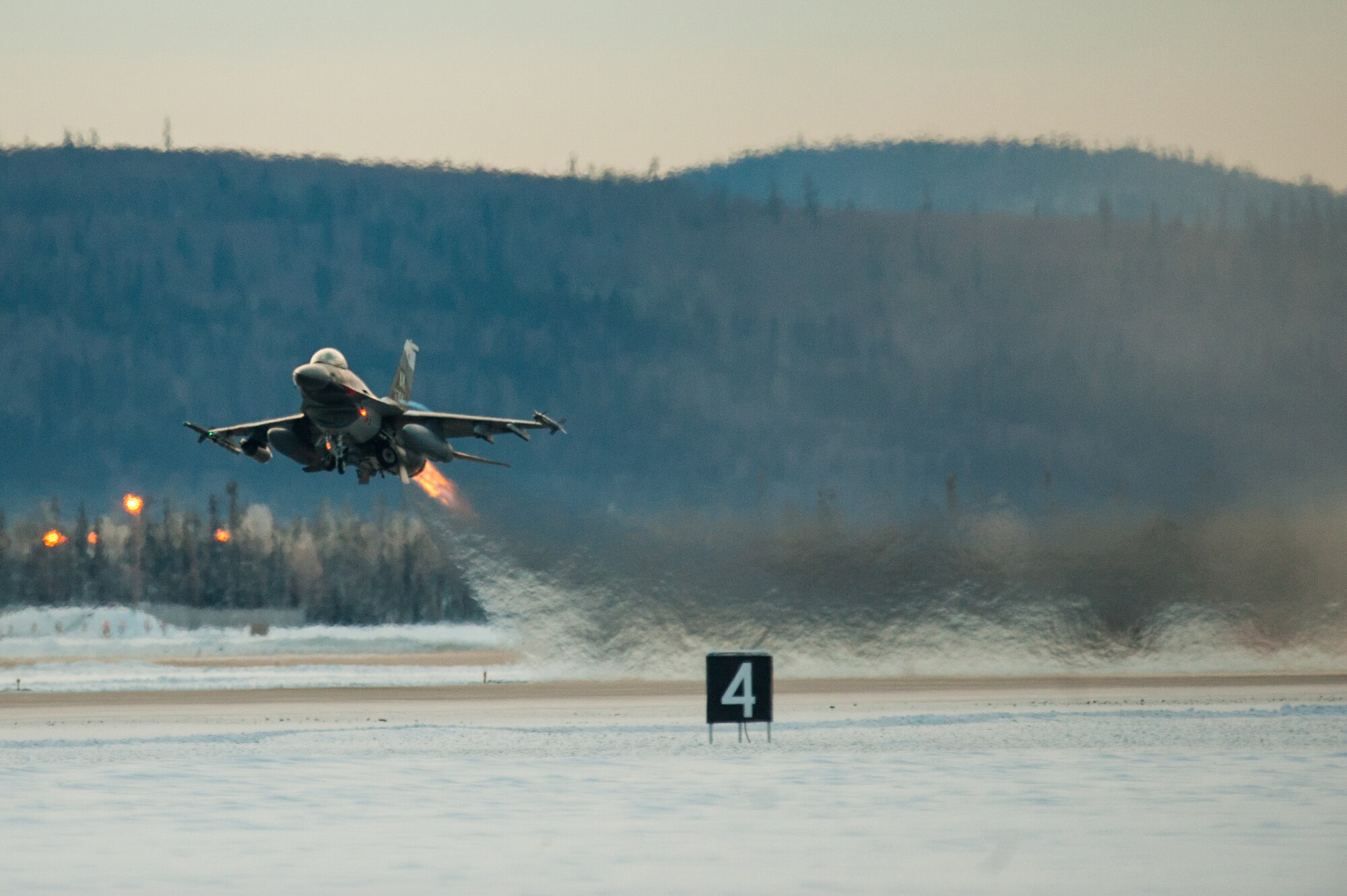One of 14 U.S. Air Force F-16 Fighting Falcon aircraft with the 18th Aggressor Squadron takes off from Eielson Air Force Base, Alaska, shortly after sunrise Jan. 17, 2015, in transit to Hickam Air Force Base, Hawaii, and Andersen Air Force Base, Guam to participate in the SENTRY ALOHA and COPE NORTH exercises. More than 150 maintainers will keep the Aggressors in the air during the exercises, which are meant to prepare U.S. Airmen, Sailors and Marines along with coalition partners in the Pacific theater of operations for contingency operations if the need arises.  (U.S. Air Force Photo by Tech. Sgt. Joseph Swafford/Released)
