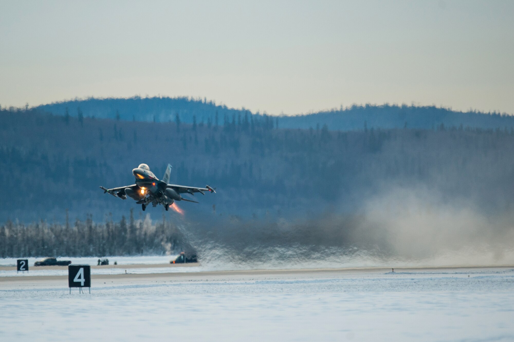 One of 14 U.S. Air Force F-16 Fighting Falcon aircraft with the 18th Aggressor Squadron takes off from Eielson Air Force Base, Alaska, shortly after sunrise Jan. 17, 2015, in transit to Hickam Air Force Base, Hawaii, and Andersen Air Force Base, Guam to participate in the SENTRY ALOHA and COPE NORTH exercises. More than 150 maintainers will keep the Aggressors in the air during the exercises, which are meant to prepare U.S. Airmen, Sailors and Marines along with coalition partners in the Pacific theater of operations for contingency operations if the need arises.  (U.S. Air Force Photo by Tech. Sgt. Joseph Swafford/Released)
