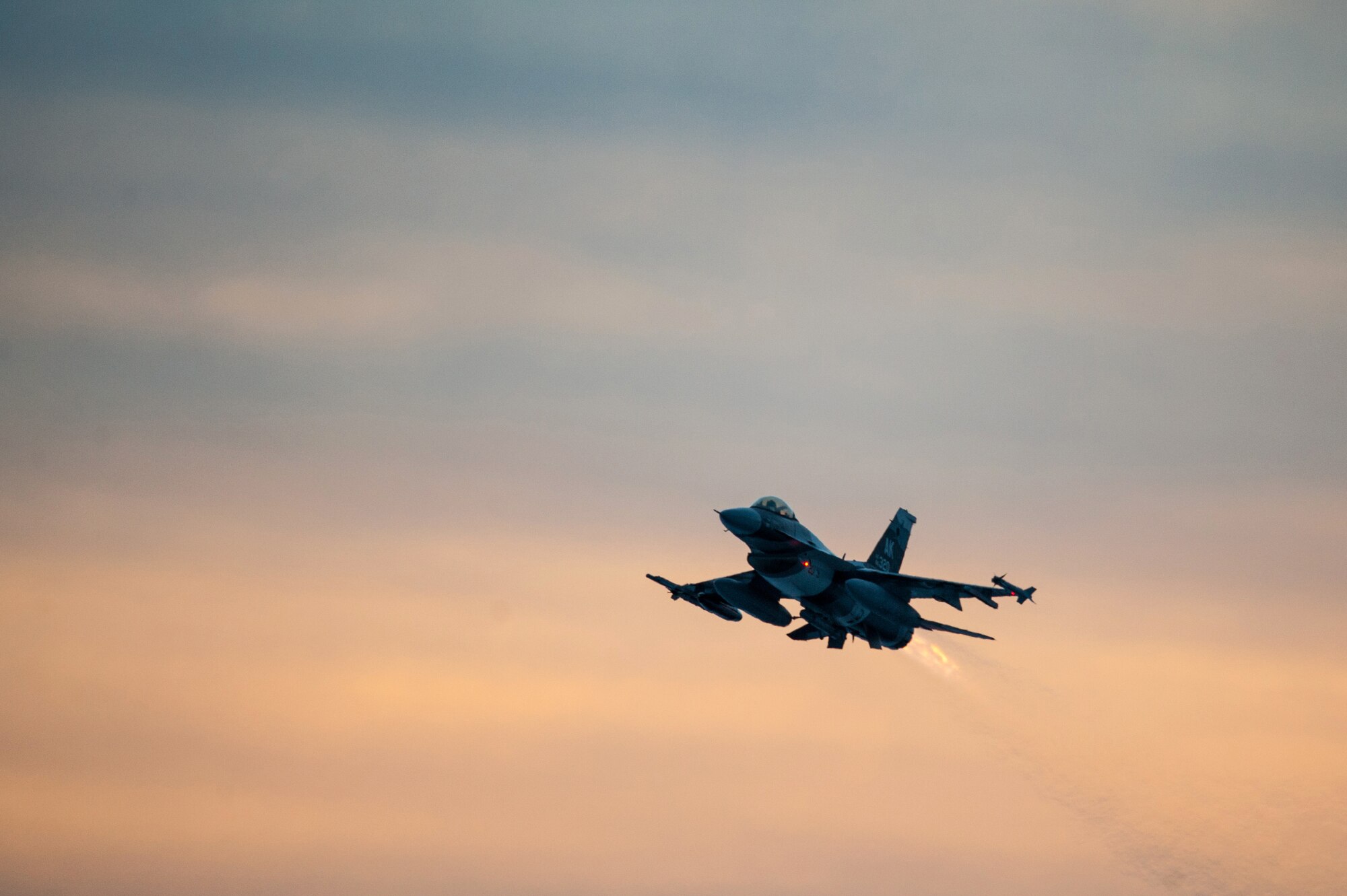 One of 14 U.S. Air Force F-16 Fighting Falcon aircraft with the 18th Aggressor Squadron takes off from Eielson Air Force Base, Alaska, shortly after sunrise Jan. 17, 2015, in transit to Hickam Air Force Base, Hawaii, and Andersen Air Force Base, Guam to participate in the SENTRY ALOHA and COPE NORTH exercises. More than 150 maintainers will keep the Aggressors in the air during the exercises, which are meant to prepare U.S. Airmen, Sailors and Marines along with coalition partners in the Pacific theater of operations for contingency operations if the need arises.  (U.S. Air Force Photo by Tech. Sgt. Joseph Swafford/Released)
