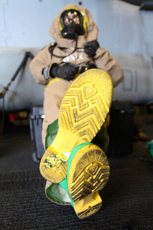 A chemical, biological, radioactive, and nuclear defense specialist with the 24th Marine Expeditionary Unit gets comfortable in a Trellchem level-B training suit during a hazardous materials equipment class aboard the amphibious assault ship USS Iwo Jima (LHD 7), Jan. 15, 2015. The 24th MEU is embarked on the ships of the Iwo Jima Amphibious Ready Group and deployed to maintain regional security in the U.S. 5th Fleet area of operations. (U.S. Marine Corps photo by Lance Cpl. Austin A. Lewis)