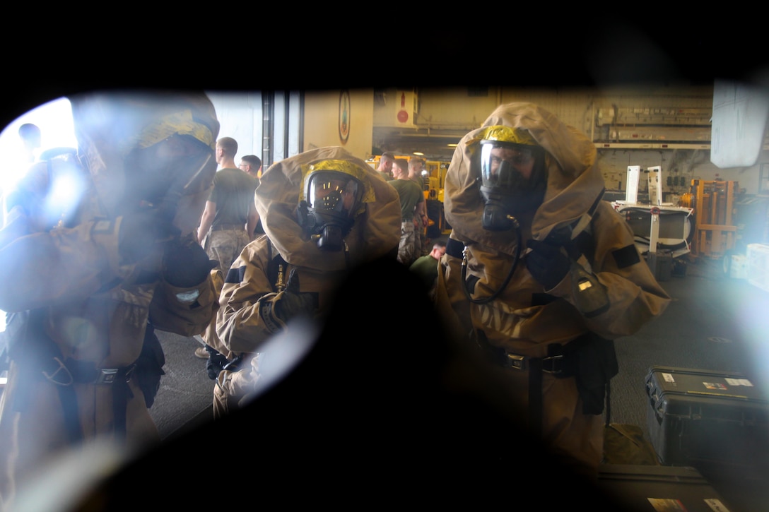 Chemical, biological, radioactive, and nuclear defense specialists with the 24th Marine Expeditionary Unit put on personal protective equipment during a hazardous materials equipment class aboard the amphibious assault ship USS Iwo Jima (LHD 7), Jan. 15, 2015. The 24th MEU is embarked on the ships of the Iwo Jima Amphibious Ready Group and deployed to maintain regional security in the U.S. 5th Fleet area of operations. (U.S. Marine Corps photo by Lance Cpl. Austin A. Lewis)