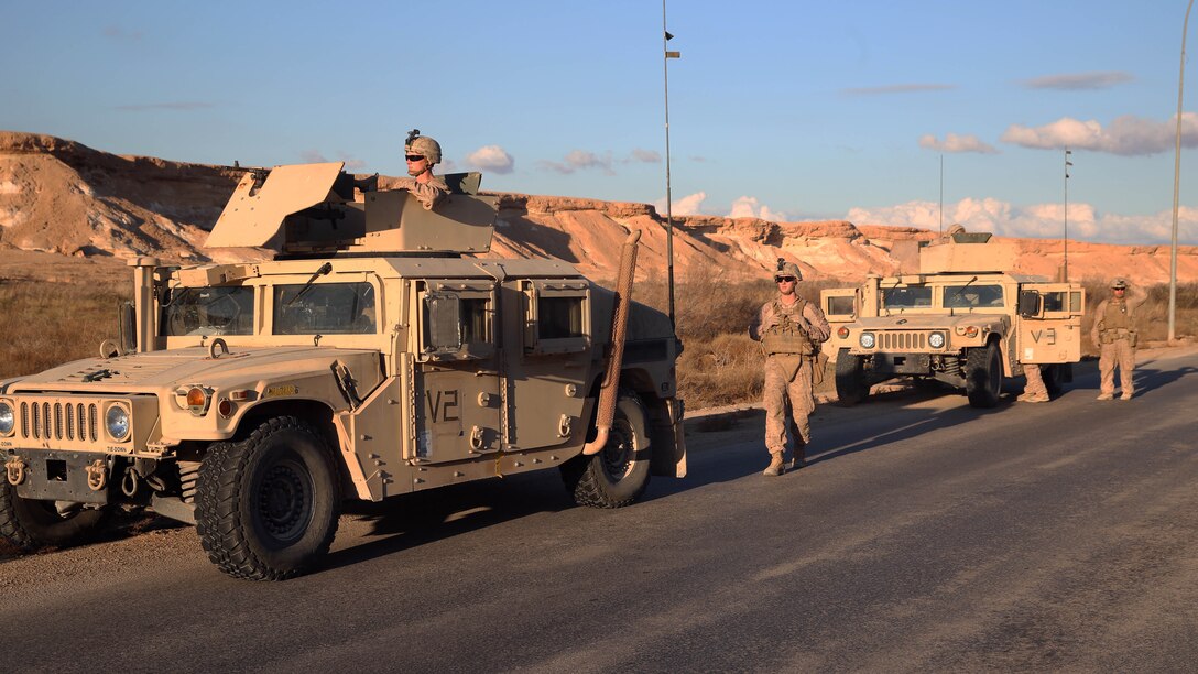 U.S. Marines with Special Purpose Marine Air Ground Task Force - Crisis Response - Central Command, Task Force Al Asad, post security for members of a U.S. Army Explosive Ordnance Disposal Company, TF Al Asad, search for the impact site of a 122 mm rocket aboard Al Asad Airbase, Iraq, Jan. 4, 2015. Soldiers and Marines are taking prudent measures to protect the members of Task Force Al Asad from the threat of indirect fire. 