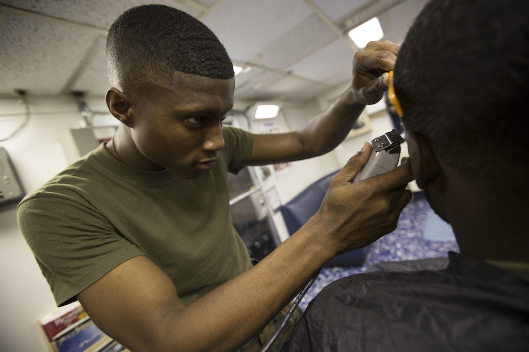 Cpl. Malik S. RolandPickens, a warehouse clerk with Combat Logistics Battalion 24, 24th Marine Expeditionary Unit, cuts a Marines hair aboard the USS Fort McHenry, at sea, Jan. 6, 2015. (U.S. Marine Corps photo by Sgt. Devin Nichols)