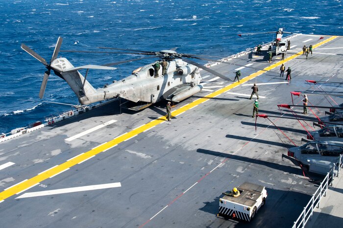 Sailors and Marines aboard amphibious assault ship USS Iwo Jima (LHD 7) prepare a CH-53E Super Stallion (left) and an AH-1W Super Cobra (right) from Marine Medium Tiltrotor Squadron 365 (Reinforced) for stowage on the flight deck Jan. 9, 2015. Iwo Jima, part of the Iwo Jima Amphibious Ready Group/24th Marine Expeditionary Unit, is conducting naval operations in the U.S. 6th Fleet area of operations in support of U.S. national security interests in Europe. (U.S. Navy photo by Mass Communication Specialist Seaman Shelby M. Tucker/ Released)