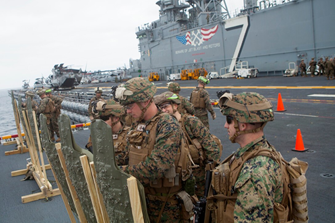 Marines assigned to Lima Company, Battalion Landing Team 3rd Battalion, 6th Marine Regiment, 24th Marine Expeditionary Unit, record their shot placements during a live-fire exercise on the flight deck aboard USS Iwo Jima Jan. 4, 2015. The 24th MEU and Iwo Jima Amphibious Ready Group are conducting naval operations in the U.S. 6th Fleet area of operations in support of U.S. national security interests in Europe. (U.S. Marine Corps photo by Lance Cpl. Austin A. Lewis/Released)