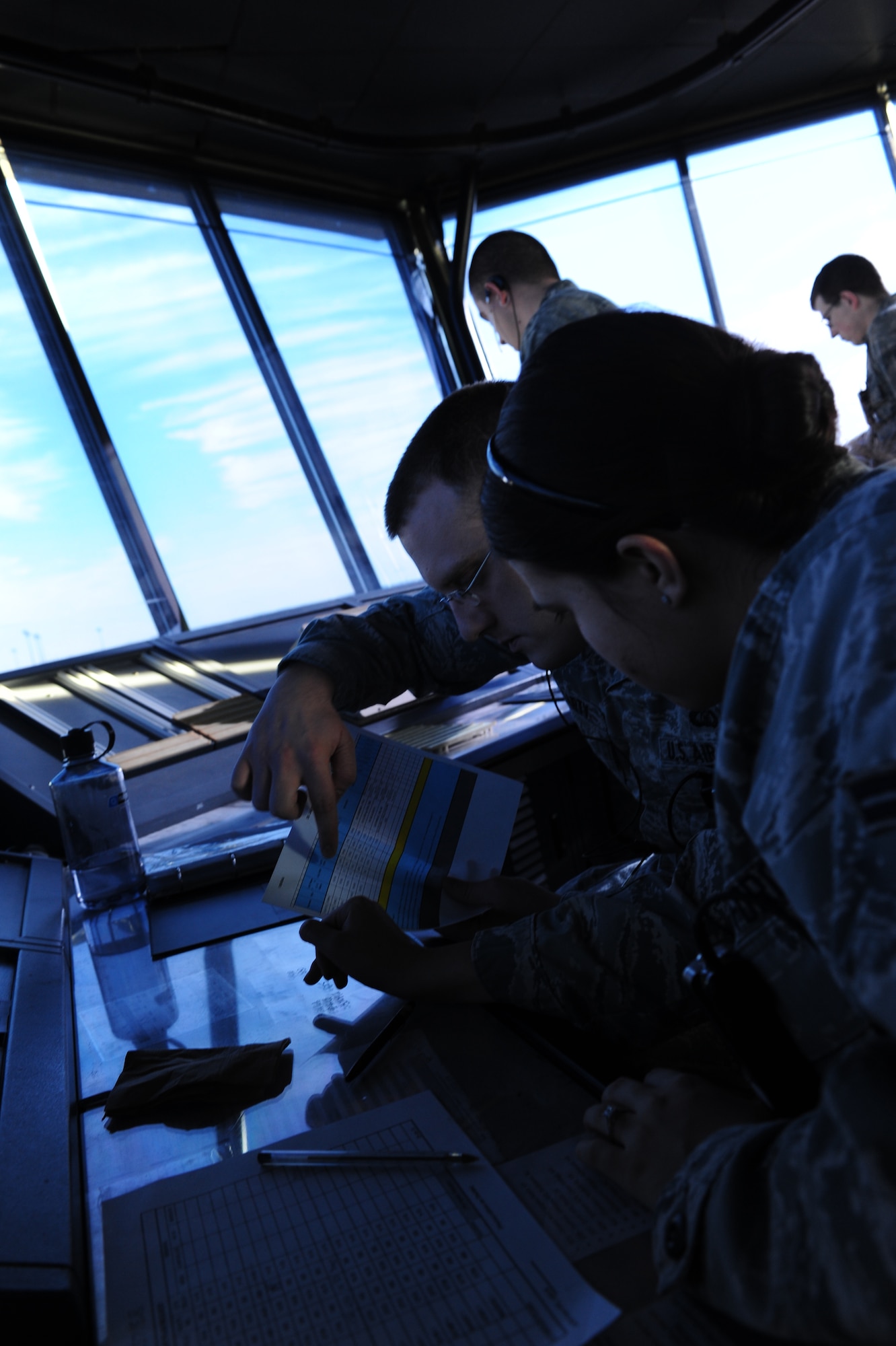 U.S. Air Force Senior Airman Michael Hegarty and Airman 1st Class Megan Andrews, 1st Operations Support Squadron air traffic controllers, look over flying schedules at Langley Air Force Base, Va., Jan. 20, 2015. The schedules are used to track departing and arriving locations of aircraft as well as when aircraft are airborne. (U.S. Air Force photo by Staff Sgt. Natasha Stannard/Released)