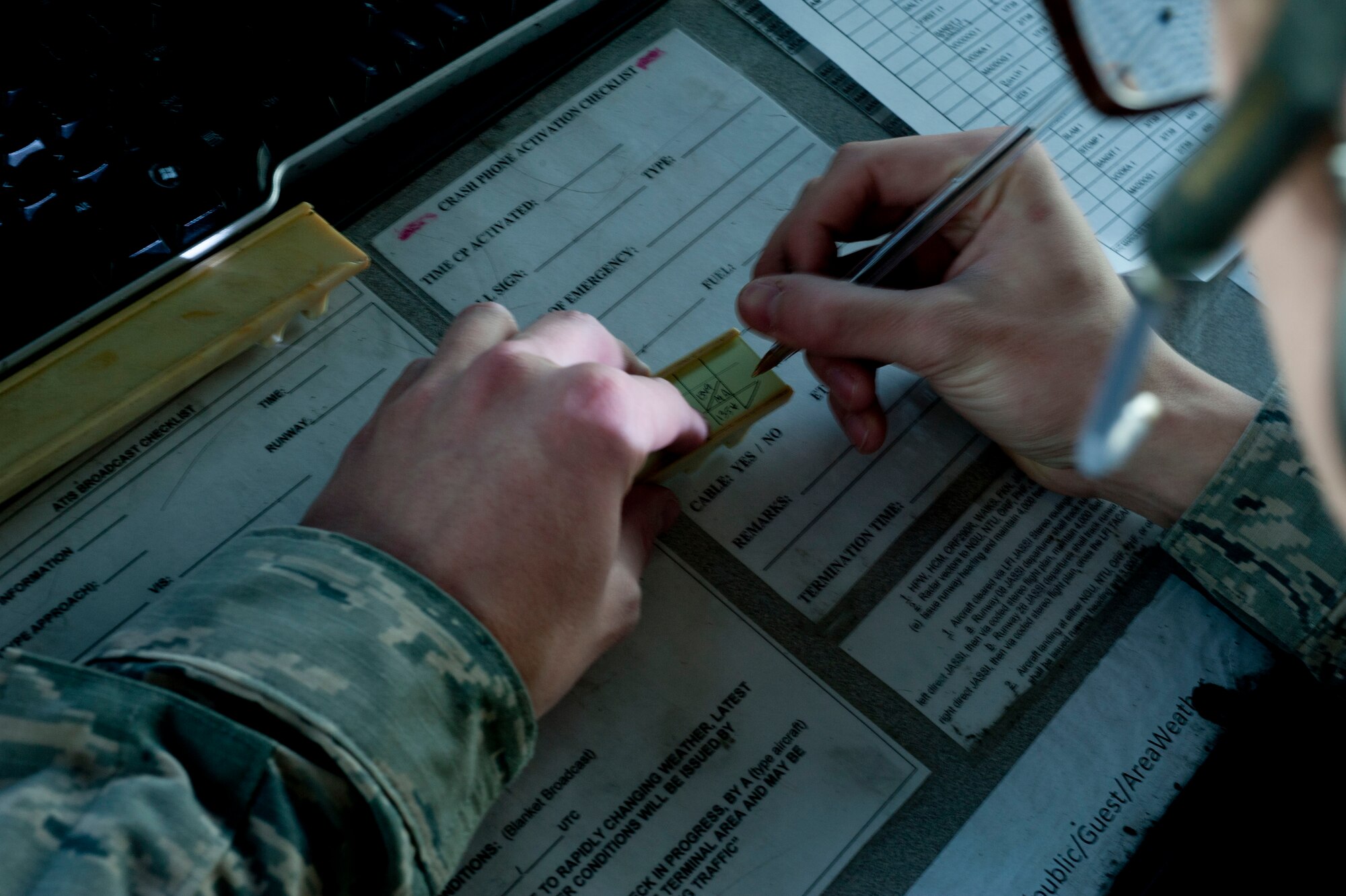 U.S. Air Force Airman 1st Class Nigel Lane, 1st Operations Support Squadron air traffic controller, logs information onto a flight strip at Langley Air Force Base, Va., Jan. 20, 2015. Flight strips are sent from either Langley AFB operations or the Norfolk Radar Center to the tower. The strips have flight information including aircraft names, destinations and clearances.  (U.S. Air Force photo by Staff Sgt. Natasha Stannard/Released)