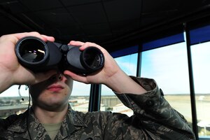 U.S. Air Force Senior Airman Joshua Shaffer, 1st Operations Support Squadron air traffic controller, looks out for an aircraft set to land at Langley Air Force Base, Va., Jan. 20, 2015. The Langley AFB control tower supports the 1st Fighter Wing flying mission in addition to NASA, transient aircraft, Fort Eustis aircraft and distinguished visitor aircraft flying missions. In fiscal year 2014, the tower supported 28,000 flying missions. (U.S. Air Force photo by Staff Sgt. Natasha Stannard/Released)