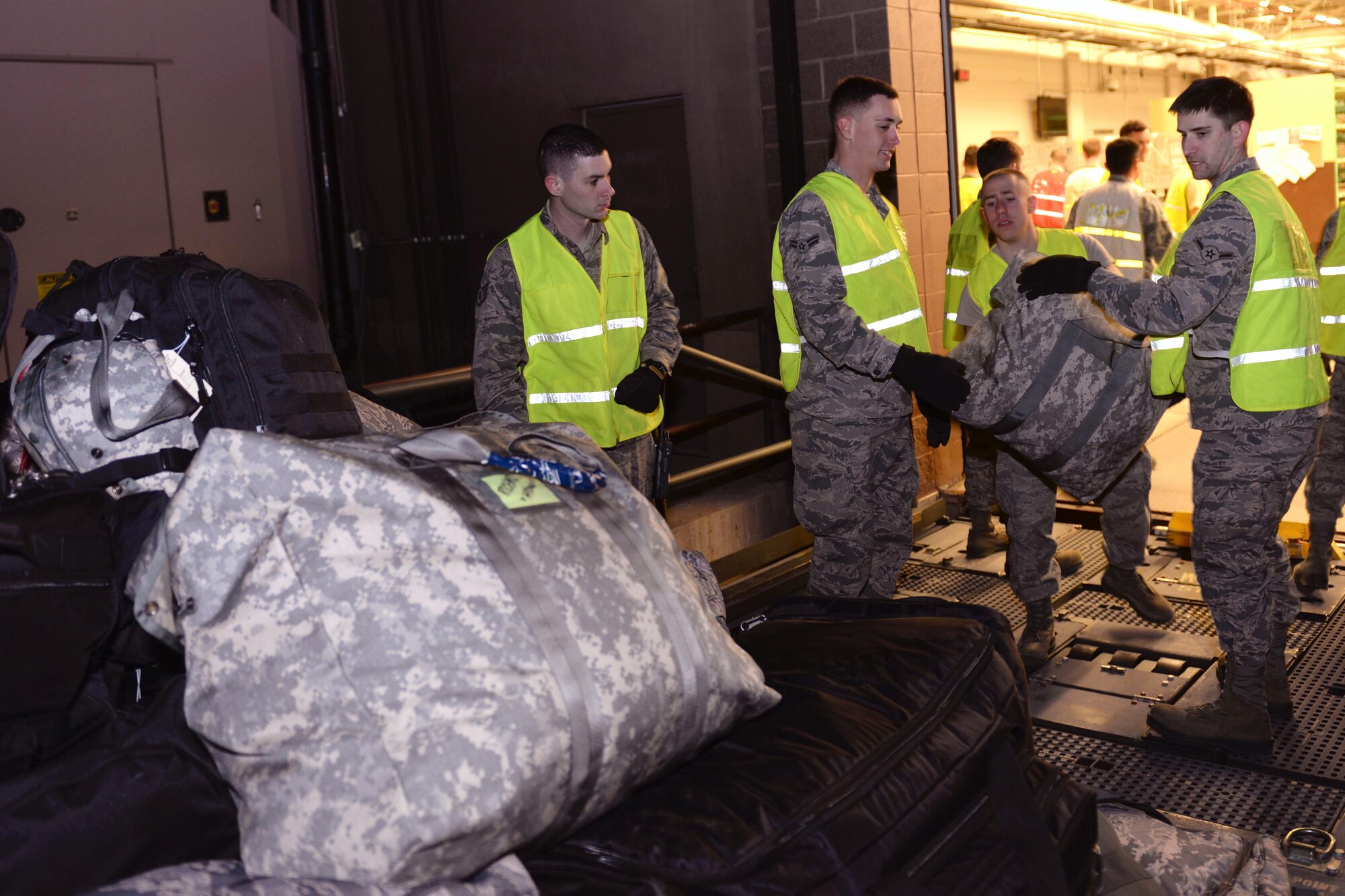 Airmen load luggage onto a truck outside the Deployment Center at Ellsworth Air Force Base, S.D., Jan. 20, 2015. Ellsworth aircrews, maintenance and support personnel will be providing operational support to the 379th Expeditionary Wing, helping ensure multirole airpower success in the U.S. Central Command area of responsibility. (U.S. Air Force photo by Airman 1st Class Rebecca Imwalle/Released)