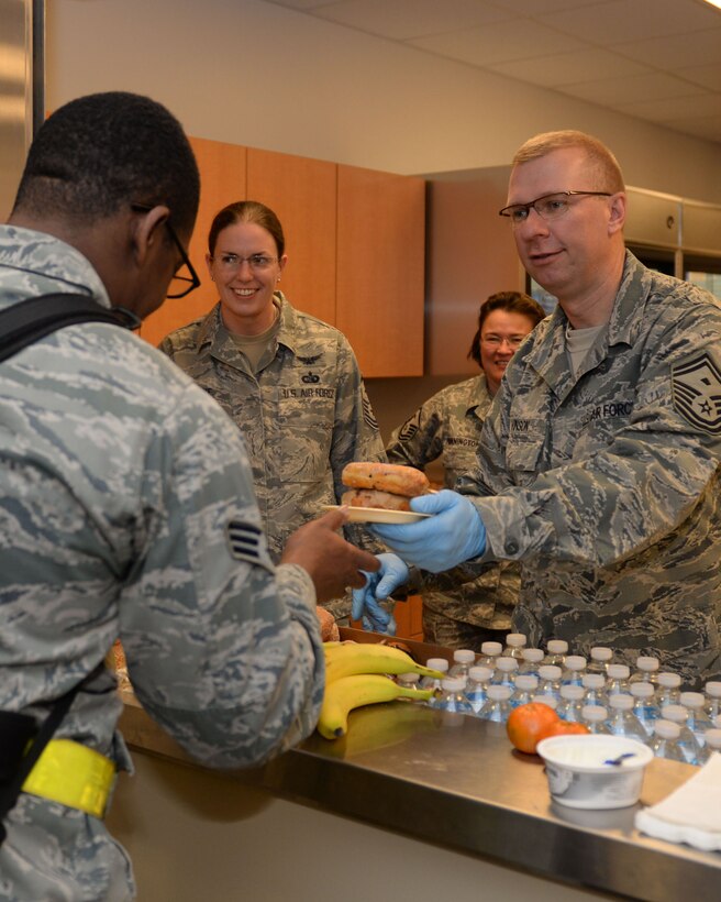 Ellsworth first sergeants serve food and drinks to deploying Airmen in the deployment center at Ellsworth Air Force Base, S.D., Jan. 20, 2015. Airmen will perform a wide range of tasks while deployed such as precision strike and surveillance and reconnaissance capabilities. (U.S. Air Force photo by Airman 1st Class Rebecca Imwalle/Released)