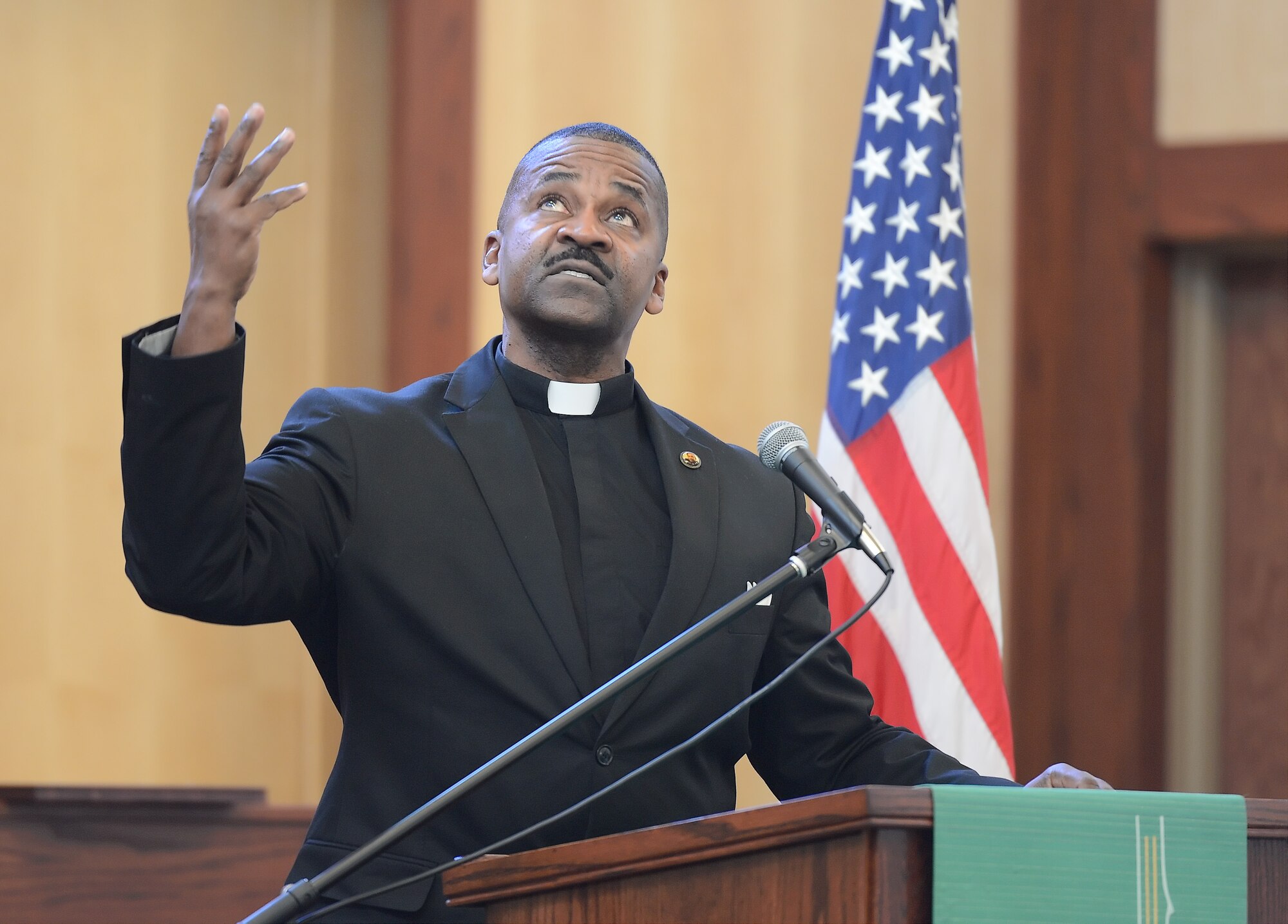 Rev. Dr. John Moore Sr., looks upwards while raising his hand emphatically during a recounting of Dr. Martin Luther King Jr.'s, 'I have a Dream Speech,' on Jan. 15, 2015, at the Dover Air Force Base, Del., main chapel. Moore delivered the speech in the same tone and style as King's original as part of the Dr. Martin Luther King Jr. Day Commemoration Service. (U.S. Air Force photo/Greg L. Davis)