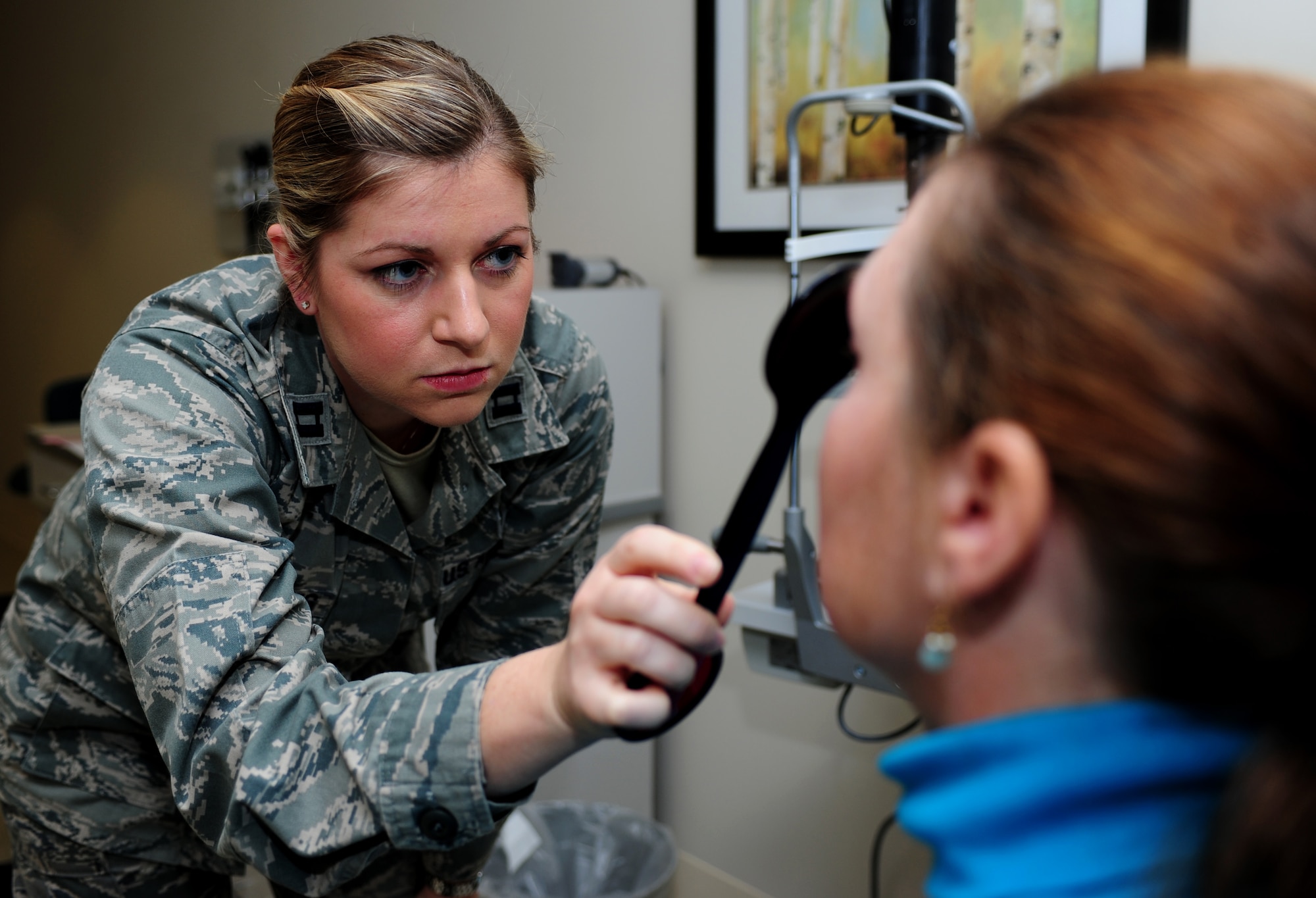 U.S. Air Force Capt. Lauren Matthews, 633rd Aerospace Medicine Squadron optometrist, checks the pupil dilation and constriction of Patricia Schlap, wife of U.S. Navy retired Senior Chief Petty Officer William Schlap, at Langley Air Force Base Va., Jan. 16, 2015.  In addition to performing routine exams, the Langley Optometry Clinic offers eye glass and contact lens prescriptions. (U.S. Air Force photo by Airman 1st Class Areca T. Wilson/Released) 