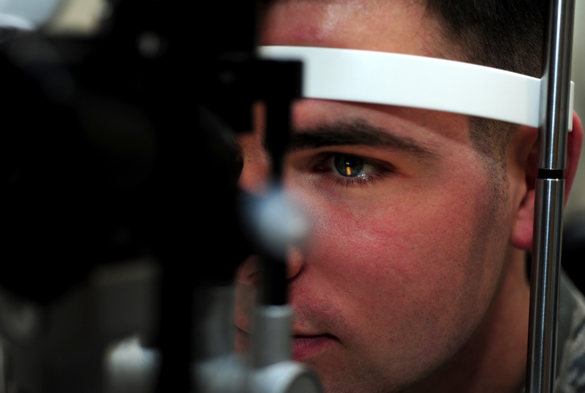U.S. Air Force Senior Airman Cole Bonack, 633rd Aerospace Medicine Squadron Optometry technician, has his eyes examined by a slit lamp at Langley Air Force Base, Va., Jan. 16, 2015. The Langley Optometry Clinic recommends U.S. Service members schedule yearly eye examinations to diagnose any issues at an early stage. (U.S. Air Force photo by Airman 1st Class Areca T. Wilson/Released)  