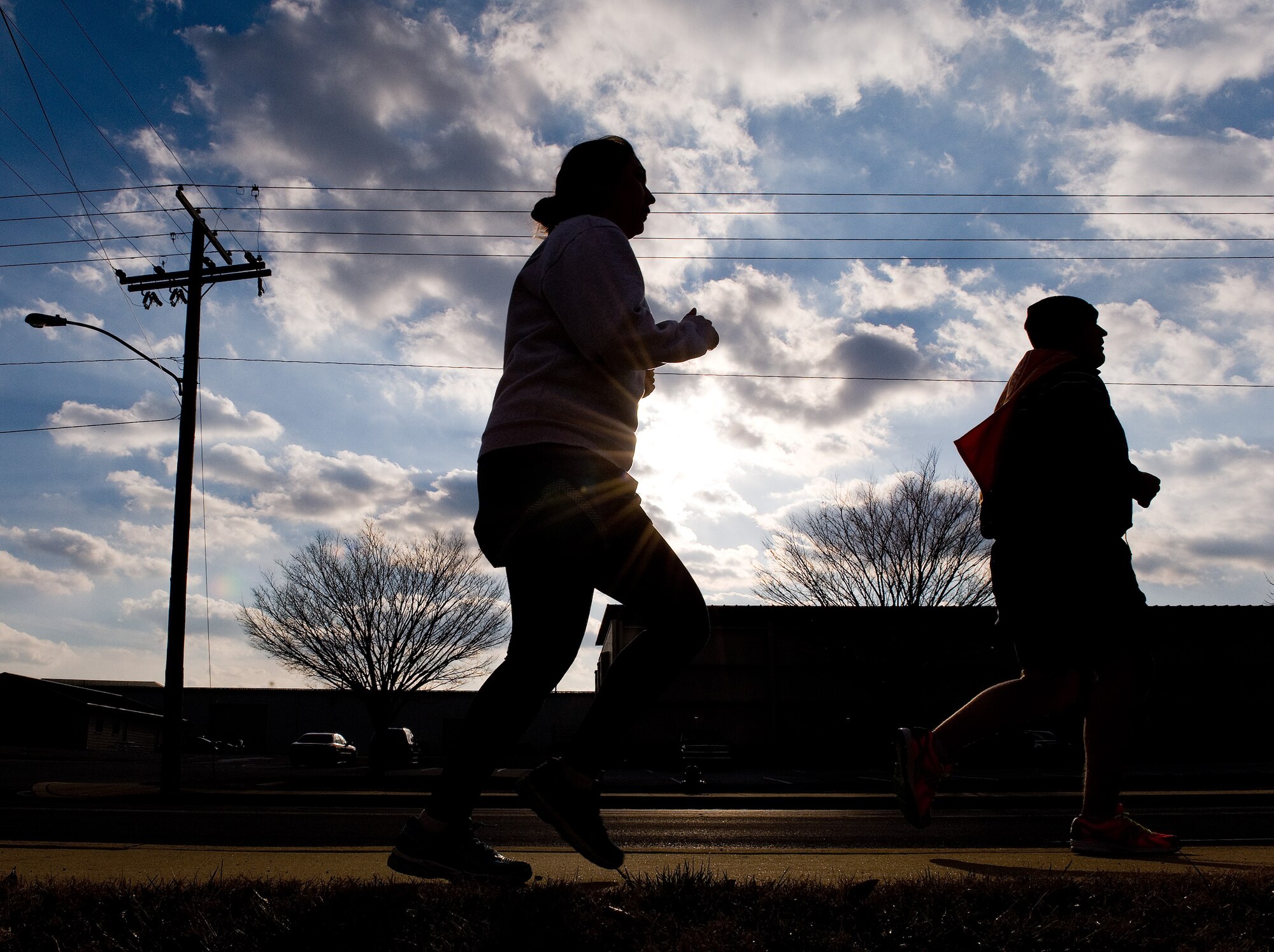 Team Dover runners head north on Atlantic Street into a brisk wind during the 2.7 mile New Year New You warrior run Jan. 16, 2015, at Dover Air Force Base, Del. With temperatures in the low 40s, runners ran into a steady 15 mile per hour headwind for the first half of the run before returning to the finish line at the Fitness Center.  (U.S. Air Force photo by Roland Balik)