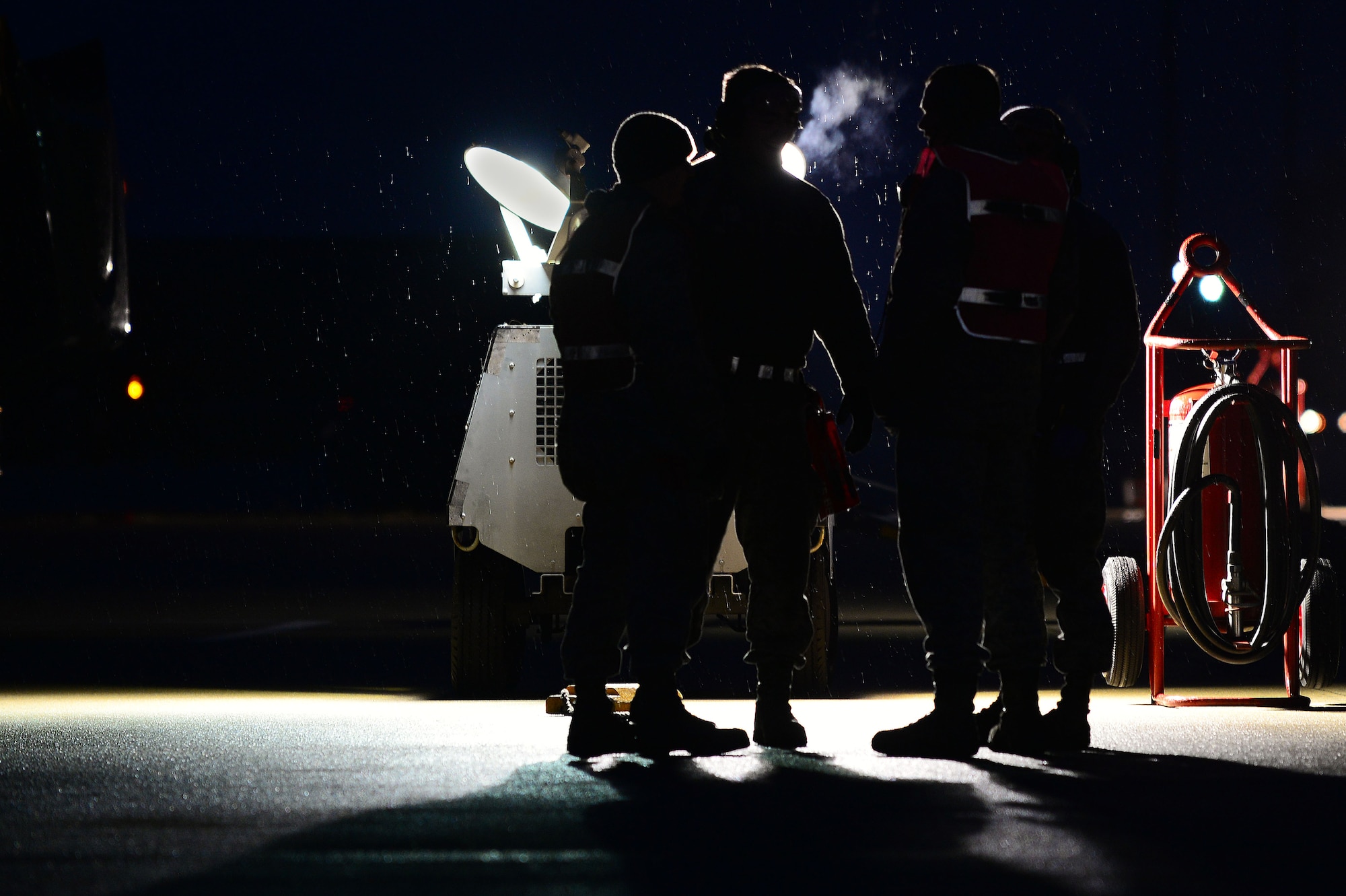 U.S. Air Force Airmen talk to each other before hot pit refueling at Shaw Air Force Base, S.C., Jan. 15, 2015. Hot pits are typically a combat refueling technique used to rapidly refuel aircrafts. (U.S. Air Force photo by Airman 1st Class Michael Cossaboom/Released)