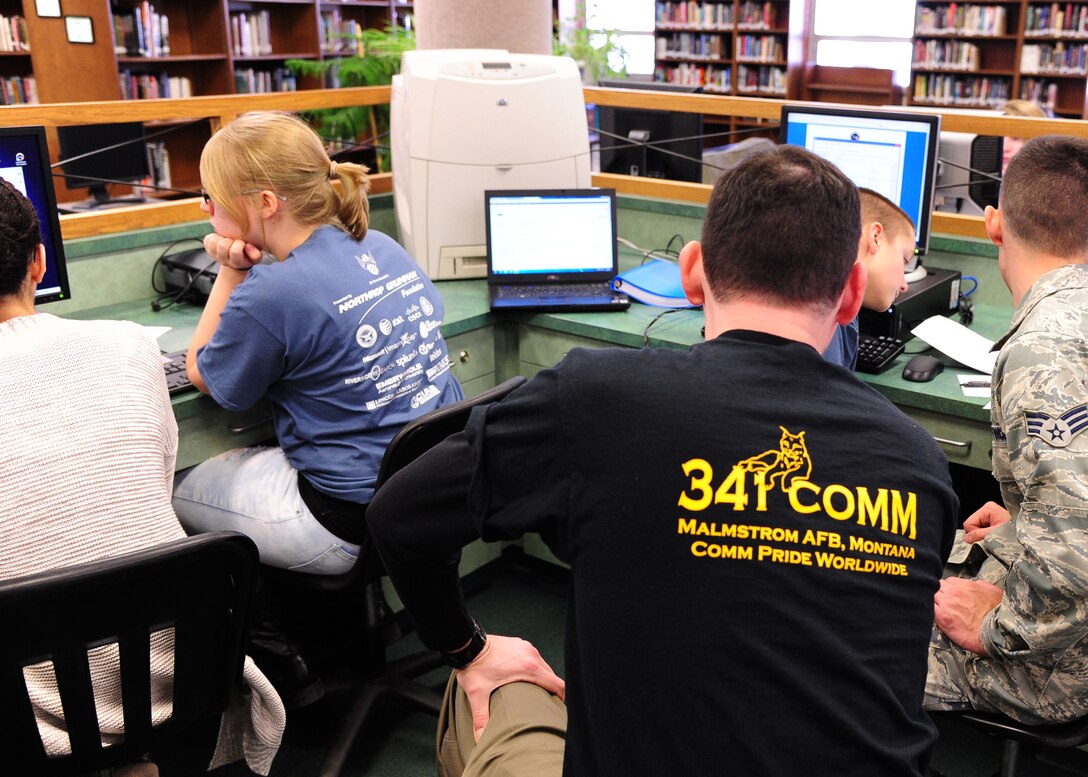Staff Sgt. Jerime Leblanc, center, and Senior Airman Austin Beaty, 341st Communications Squadron members, mentor students of Montana’s first and only national youth cyber education program known as CyberPatriots Jan. 16, 2015, at Charles M. Russell High School.  The CyberPatriots competed in their first regional competition in Great Falls, Mont. (U.S. Air Force photo/2nd Lt. Annabel Monroe)