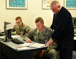 U.S. Army Staff Sgt. Kenneth Spencer, Joint Deployment Training Center student, receives instructions from Dave Terrell, JDTC instructor, at Fort Eustis, Va., Jan. 9, 2014. JDTC instructors teach courses in joint deployment, global force management and situational awareness in classrooms, online or from a remote location. (U.S. Air Force photo by Senior Airman Kimberly Nagle/Released)