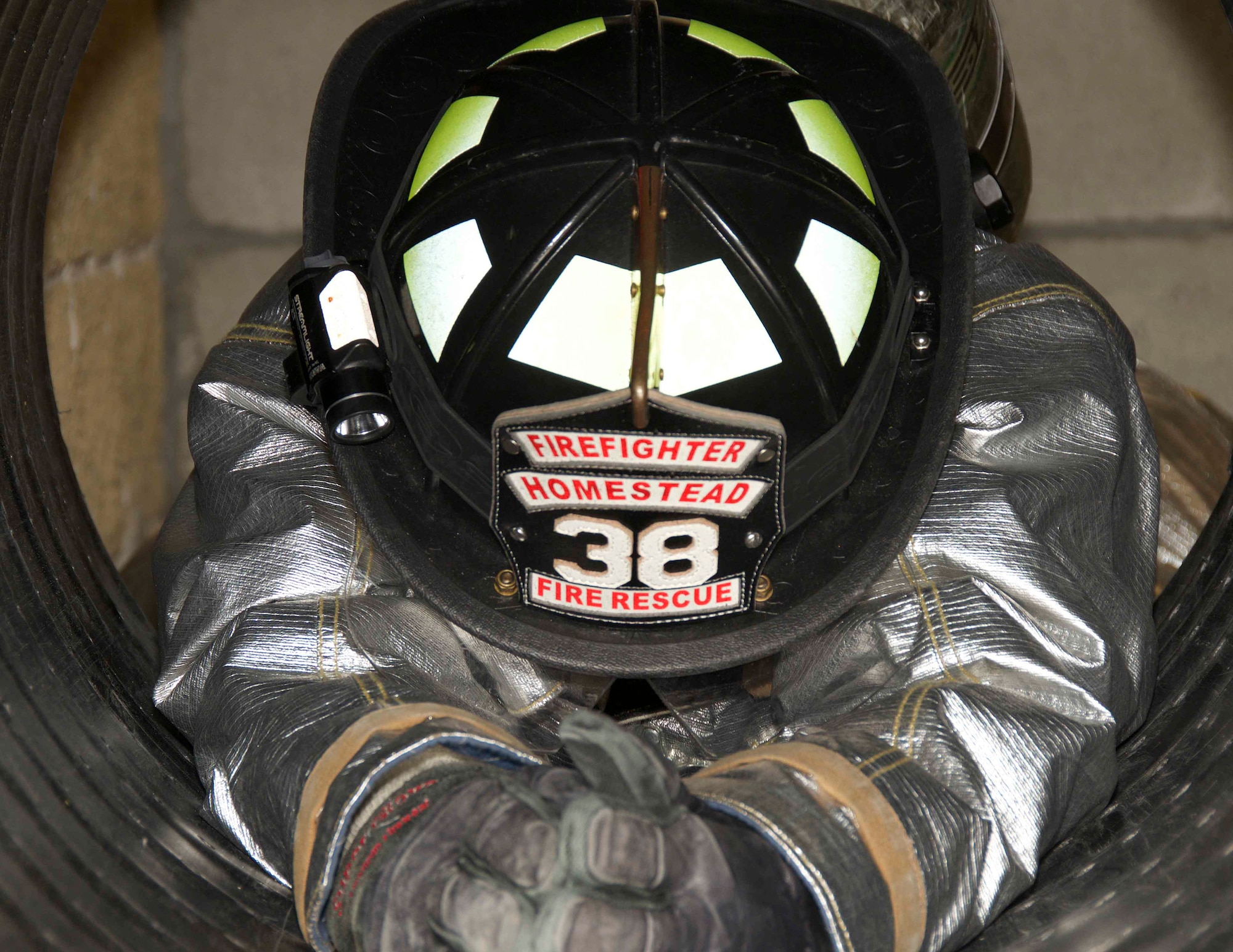 Tech. Sgt. Oscar Lopez, 482nd Prime BEEF (base engineer emergency force) Fire Flight fire protection technician at Homestead Air Reserve Base, Fla., wiggles his way down a smooth, cylinder tube as part of a confined spaces training at the Miami-Dade County Fire Rescue Training Complex in Doral, Fla., Jan. 8. The training taught the Airman different techniques for getting themselves and all their gear through small openings safely and gave them an opportunity to experience what being in a confined space feels like. (U.S. Air Force photo by Senior Airman Jaimi L. Upthegrove)