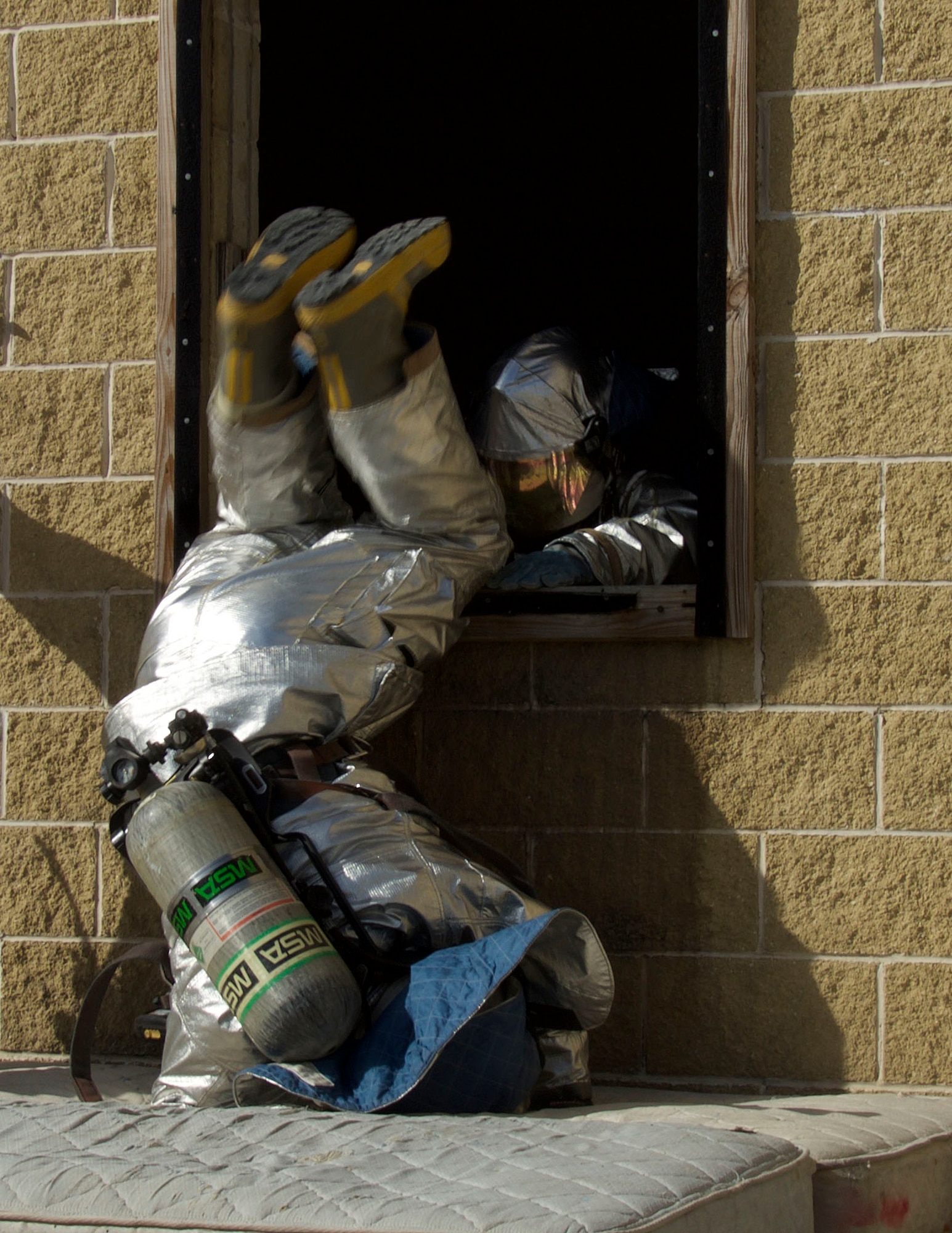 Senior Airman Angelo Viniegra, 482nd Prime BEEF (base engineer emergency force) Fire Flight fire protection technician at Homestead Air Reserve Base, Fla., jumps out of a window during a training at the Miami-Dade County Fire Rescue Training Complex in Doral, Fla., Jan. 8. In the scenario, his team was almost out of air and they had 20 seconds to get out of the building. (U.S. Air Force photo by Senior Airman Jaimi L. Upthegrove)