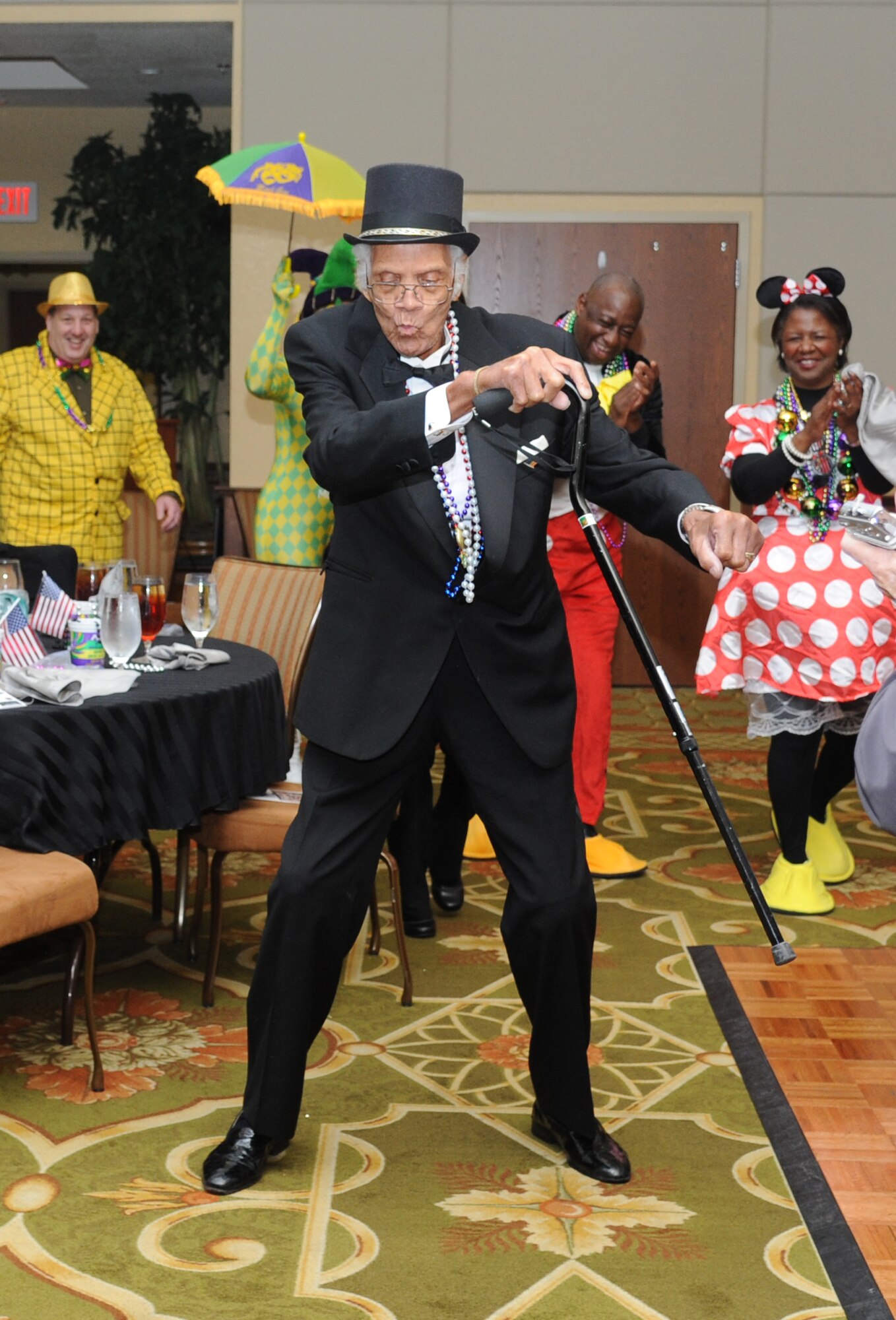 Ninety-one-year-old James Taylor, World War II veteran, dances during the Keesler Medical Center’s 27th annual Krewe of Medics Mardi Gras Ball Jan. 17, 2015, at the Bay Breeze Event Center, Keesler Air Force Base, Miss.  The Krewe of Medics hosts a ball every year to give military personnel assigned to the Keesler Medical Center a taste of the South and an opportunity to experience a traditional Mardi Gras.  The theme of this year's ball was TV Icons. Maj. Marlon Muthuveeran, 81st Medical Support Squadron medical readiness flight commander was crowned King and Sarah Jacobs, Krewe of Medic member, was crowned Queen. (U.S. Air Force photo by Kemberly Groue)