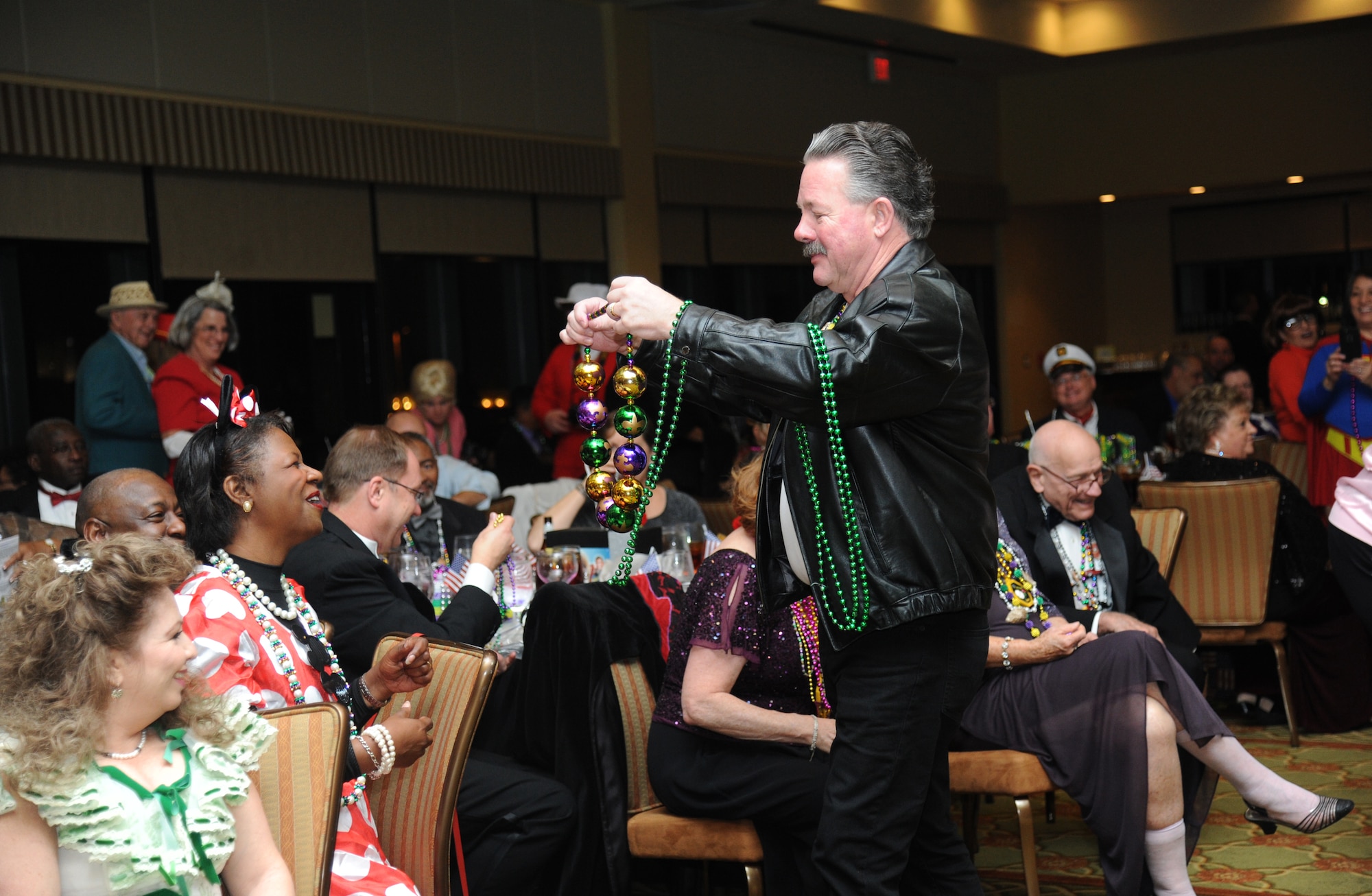 David Forney, 336th Training Squadron client systems instructor, passes out beads during the Keesler Medical Center’s 27th annual Krewe of Medics Mardi Gras Ball Jan. 17, 2015, at the Bay Breeze Event Center, Keesler Air Force Base, Miss.  The Krewe of Medics hosts a ball every year to give military personnel assigned to the Keesler Medical Center a taste of the South and an opportunity to experience a traditional Mardi Gras.  The theme of this year's ball was TV Icons. (U.S. Air Force photo by Kemberly Groue)
