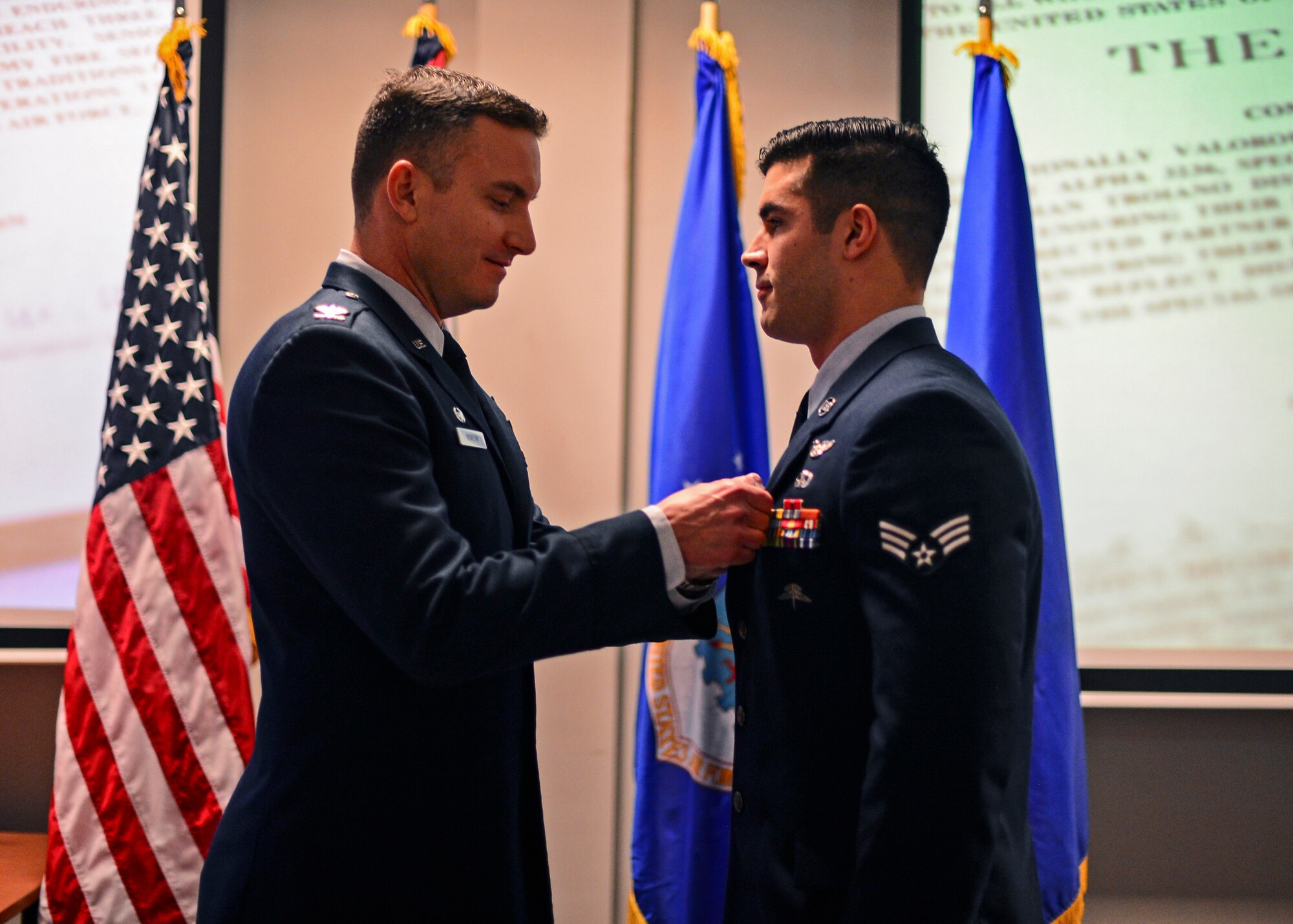 Col. Robert Novotny, 48th Fighter Wing commander, presents Senior Airman Frank Troiano, 56th Rescue Squadron pararescueman, the Bronze Star Medal at the Strike Eagle Complex during an Installation Excellence Selection Board visit on Royal Air Force Lakenheath, England, Jan. 15, 2015. Troiano distinguished himself by exposing himself to enemy fire to reach three Afghan casualties, ensuring their proper care and transport to a higher level treatment facility. (U.S. Air Force photo by Airman 1st Class Erin R. Babis/Released)