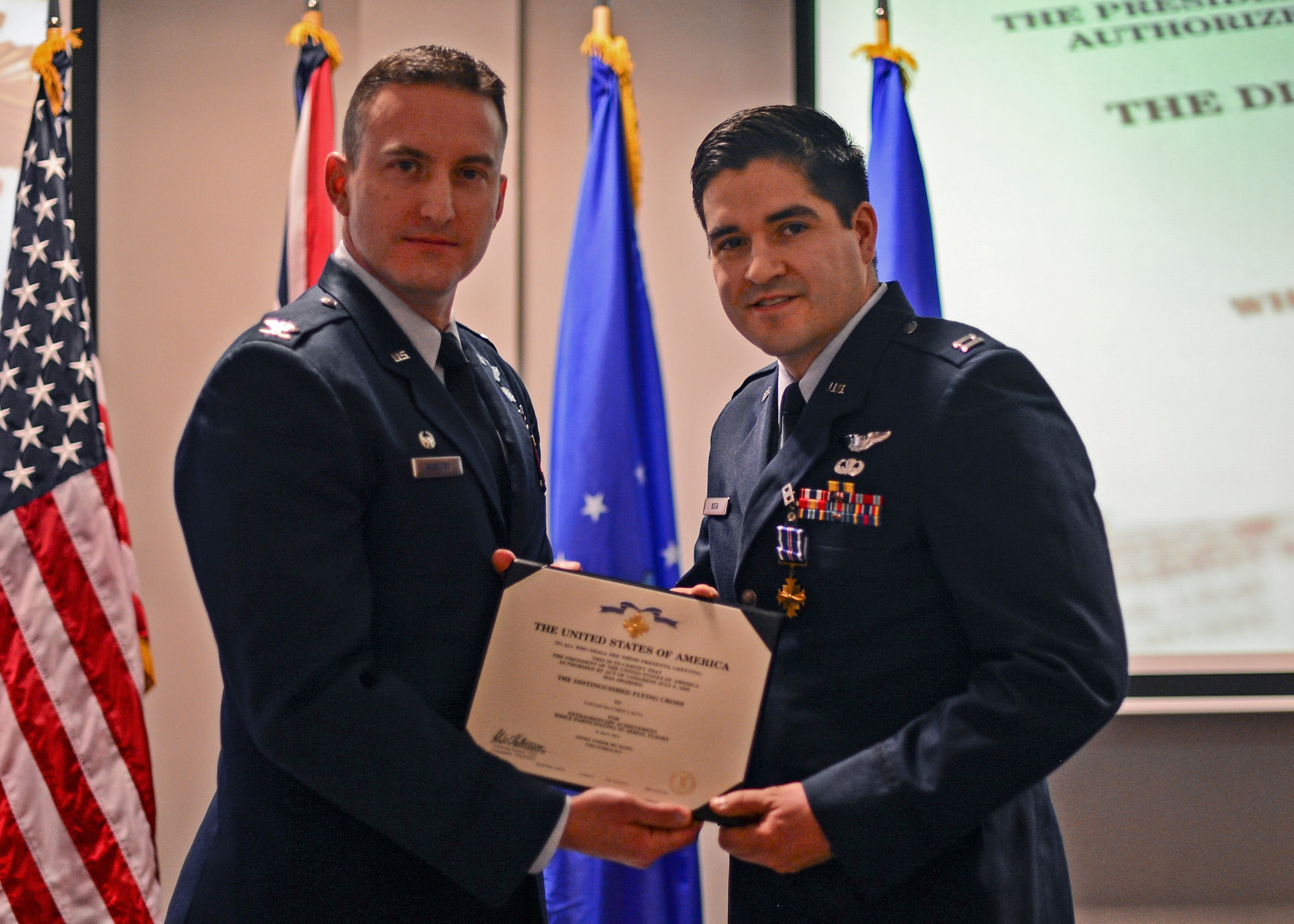 Col. Robert Novotny, 48th Fighter Wing commander, presents Capt. Matthew Kuta, 492nd Fighter Squadron pilot, the Distinguished Flying Cross at the Strike Eagle Complex during an Installation Excellence Selection Board visit on Royal Air Force Lakenheath, England, Jan. 15, 2015. Kuta led two F-15Es responding to troops in a contact situation in support of Operation ENDURING FREEDOM in Afghanistan, May 21, 2014. (U.S. Air Force photo by Airman 1st Class Erin R. Babis/Released)