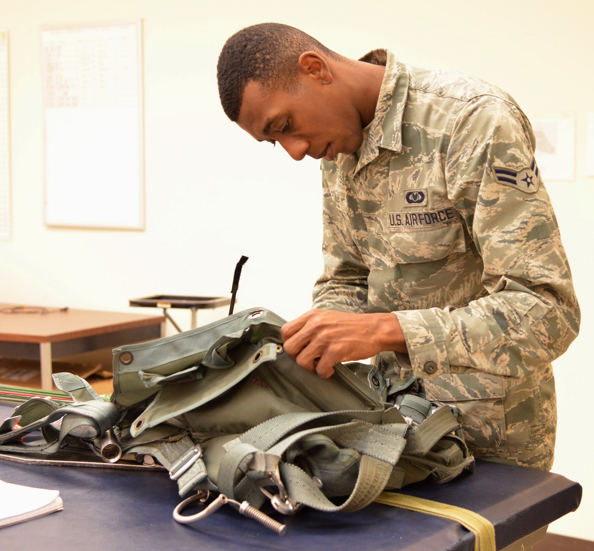 Airman 1st Class Rashaun Carter, an aircrew flight equipment technician in the 58th Operations Support Squadron, packs a parachute. Carter was selected for the Kirtland Warrior recognition. (Photo by Jamie Burnett)