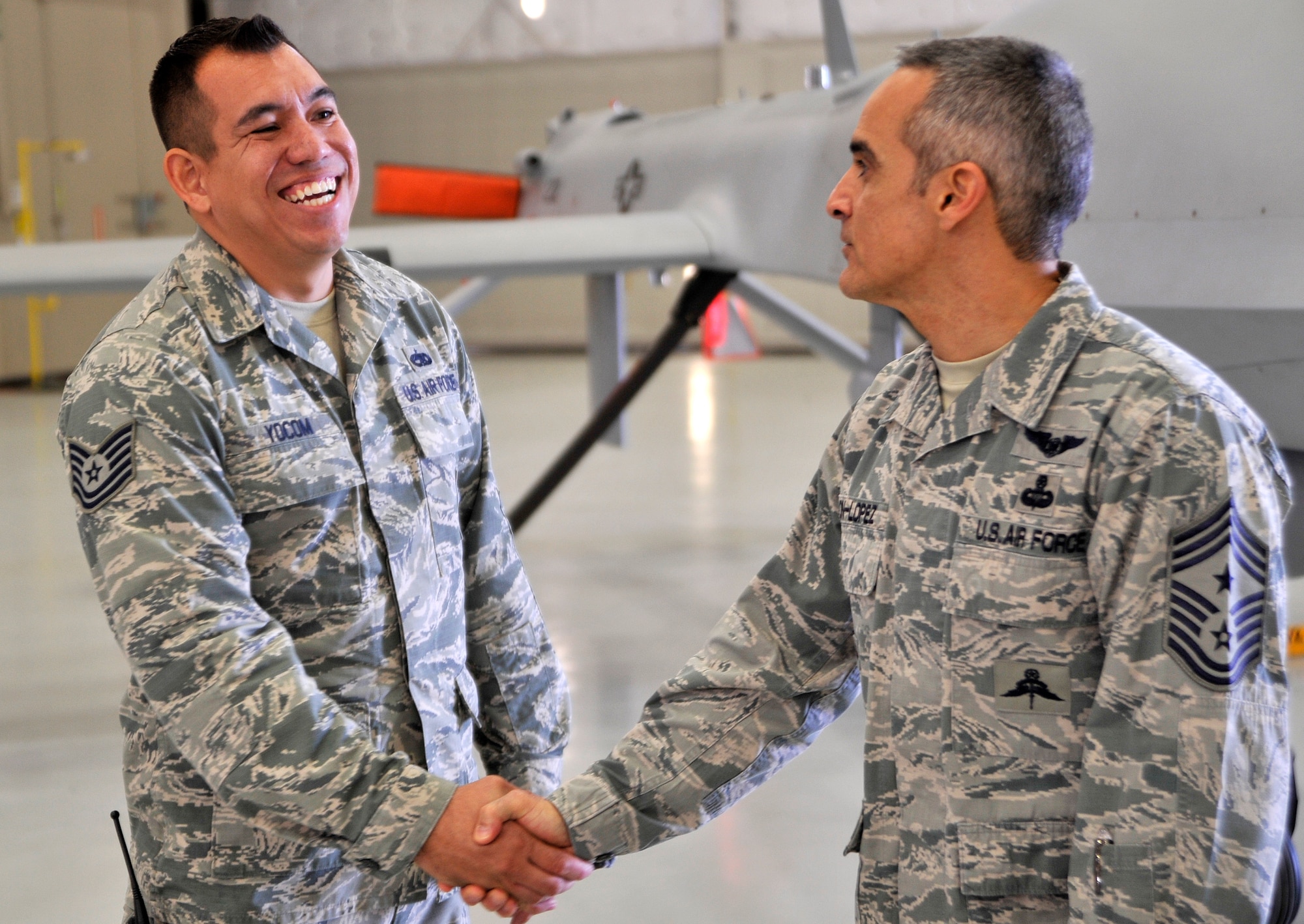 Tech. Sgt. David Yocom, 432nd Aircraft Maintenance Squadron weapons expeditor, left, shakes hands with Chief Master Sgt. Ramon Colon-Lopez, U.S. Air Forces Central Command command chief during his visit Jan. 15, 2015, to Creech Air Force Base, Nevada. The chief coined Yocom for his overall excellence as an Airman and as a supervisor. (U.S. Air Force photo by Airman 1st Class Christian Clausen/Released)