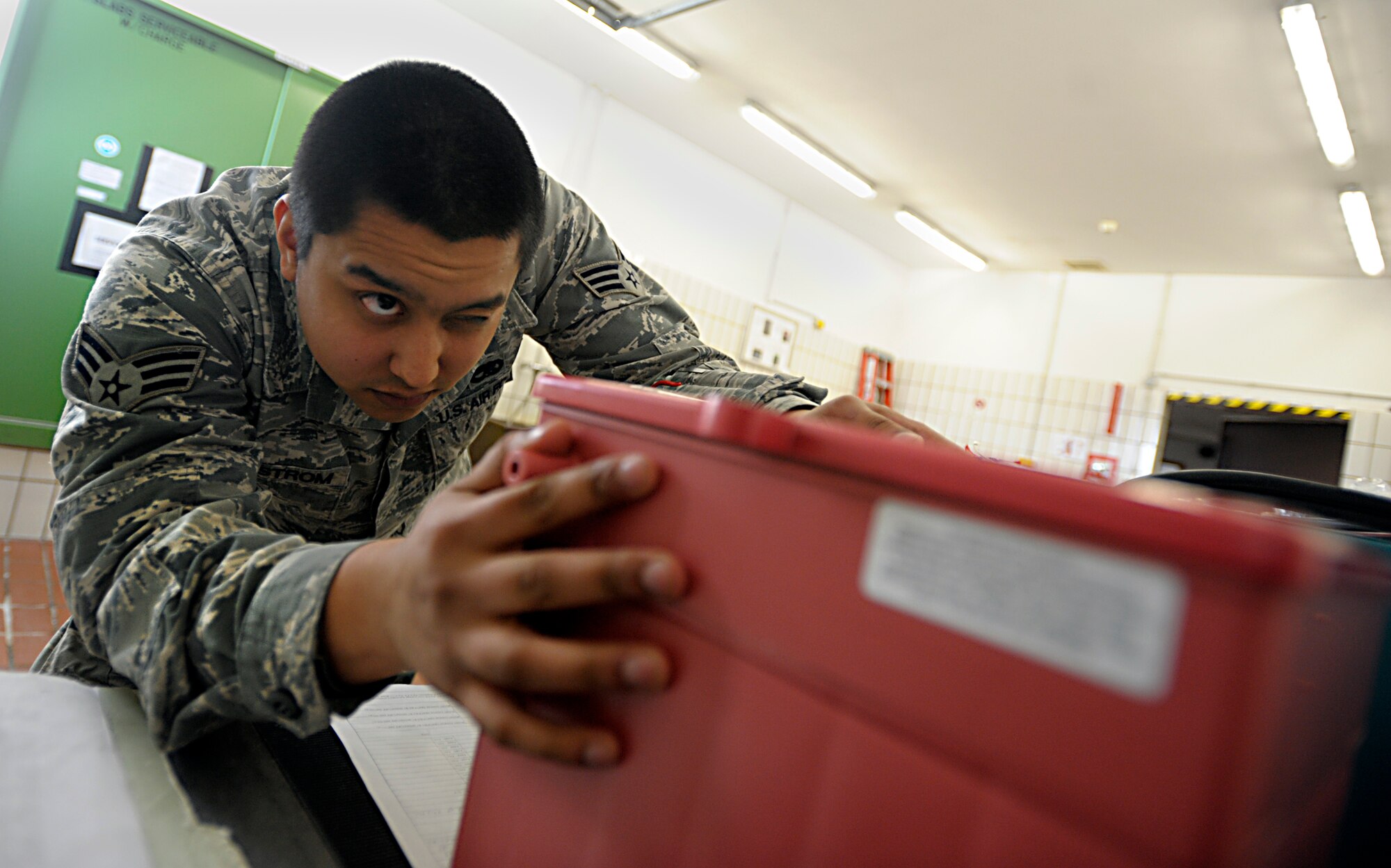 Senior Airman Gabriel Sundstrom, 86th Maintenance Squadron electrical and environmental specialist, checks for damage on a battery at Ramstein Air Base, Germany, Jan. 15, 2015. The electrical and environmental systems flight performs pre-flight and preventative maintenance on all aircraft and systems to keep them operational for mission readiness. (Senior Airman Timothy Moore/Released)
