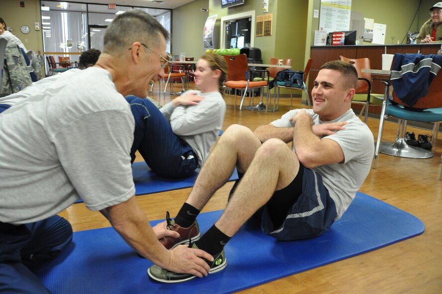 Lt. Col. Kennith Wright, commander of the 476th Medical Detachment, holds the feet of Senior Airman Aaron Joyner, a medical technician, during “combat bowling” January 11 at Moody Air Force Base, Georgia. Combat bowling penalizes opponents with activities such as pushups, setups or jumping jacks based on the bowling pins knocked down. Wright chose to take the detachment bowling during their Unit Training Assembly as an indoor inclimate weather activity. (Photo by Tech. Sgt. Emily F. Alley)