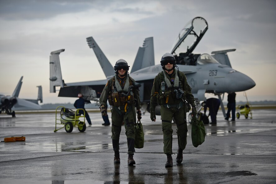 Two pilots with the VFA-106 Strike Fighter Squadron, Oceana Naval Air Station, Va., walk away from an F-18 Super Hornet after a training flight at MacDill Air Force Base, Fla., Jan. 9, 2015. Pilots trained on air-to-ground scenarios at MacDill’s Avon Park Air Force Range. (U.S. Air Force photo by Senior Airman Ned T. Johnston/Released)