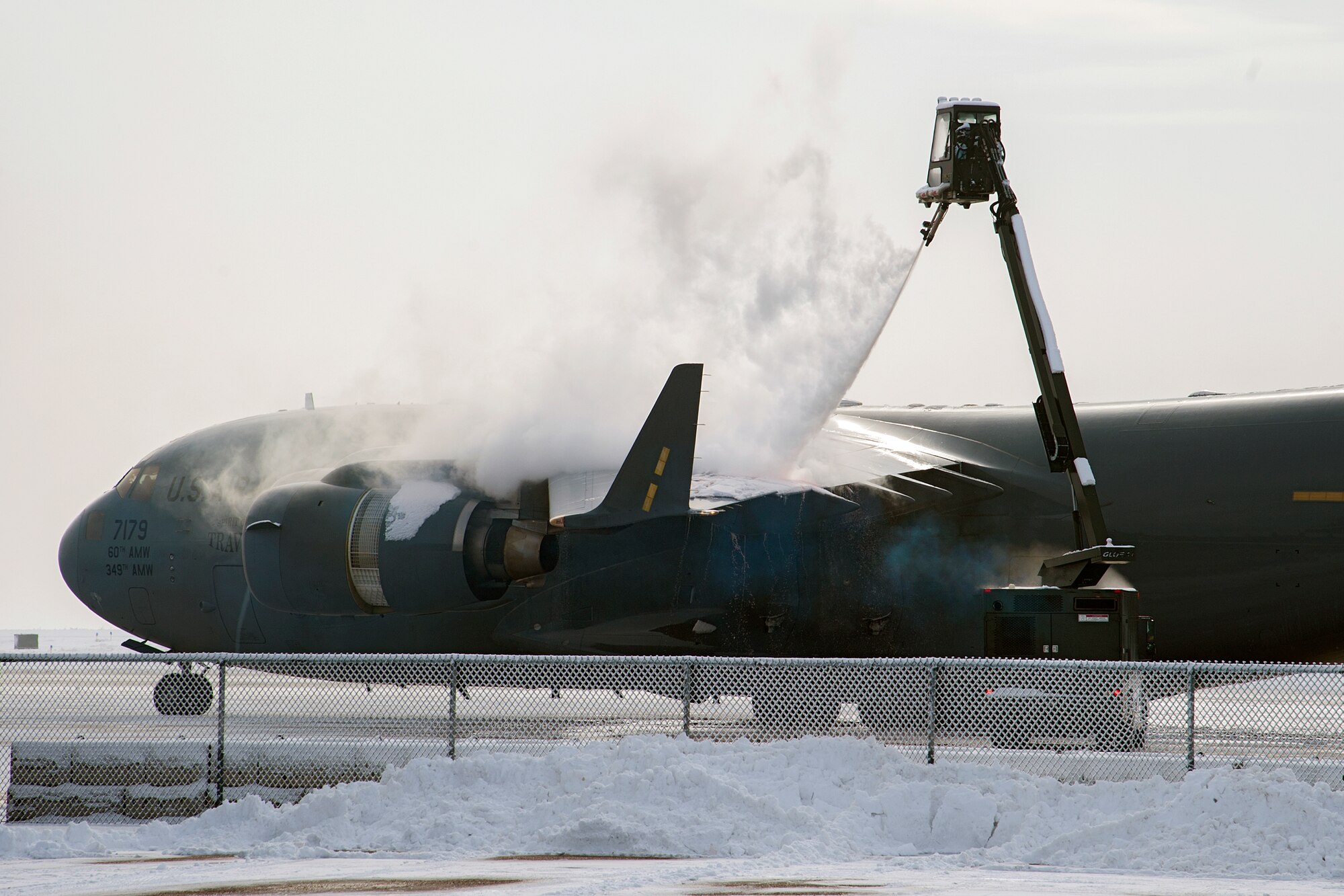 PETERSON AIR FORCE BASE, Colo. – Personnel from the 21st Operations Support Squadron de-ice a C-17 Globemaster Jan. 13 at the Peterson flightline. The aircraft was from Travis AFB. Snow and ice on an aircraft can decrease lift, increase drag and cause a crash, making the 21st OSS support invaluable to flight safety. (U.S. Air Force photo by Craig Denton)