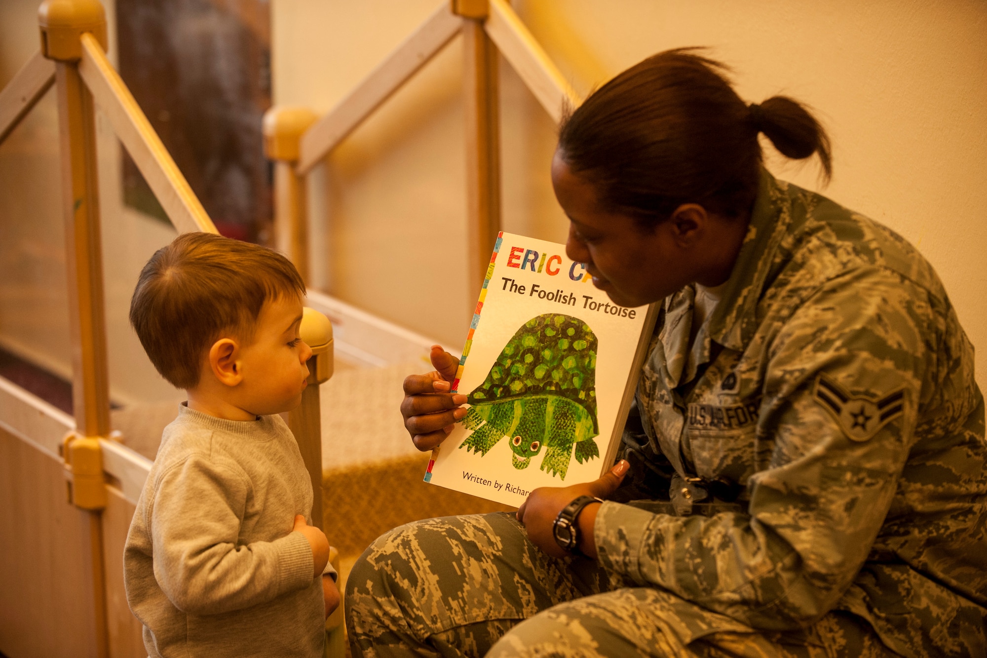 U.S. Air Force Davida Sims, a 52nd Maintenance Group commander's support staff apprentice, displays a book to a child during the second annual Dr. Martin Luther King Jr. "Reading is a Civil Right" reading drive Jan. 15, 2015, at a child development center at Spangdahlem Air Base, Germany. More than 50 volunteers signed up for the event that was sponsored by the base’s Airmen Against Drunk Driving council and the CDC. (U.S. Air Force photo by Senior Airman Rusty Frank/Released)